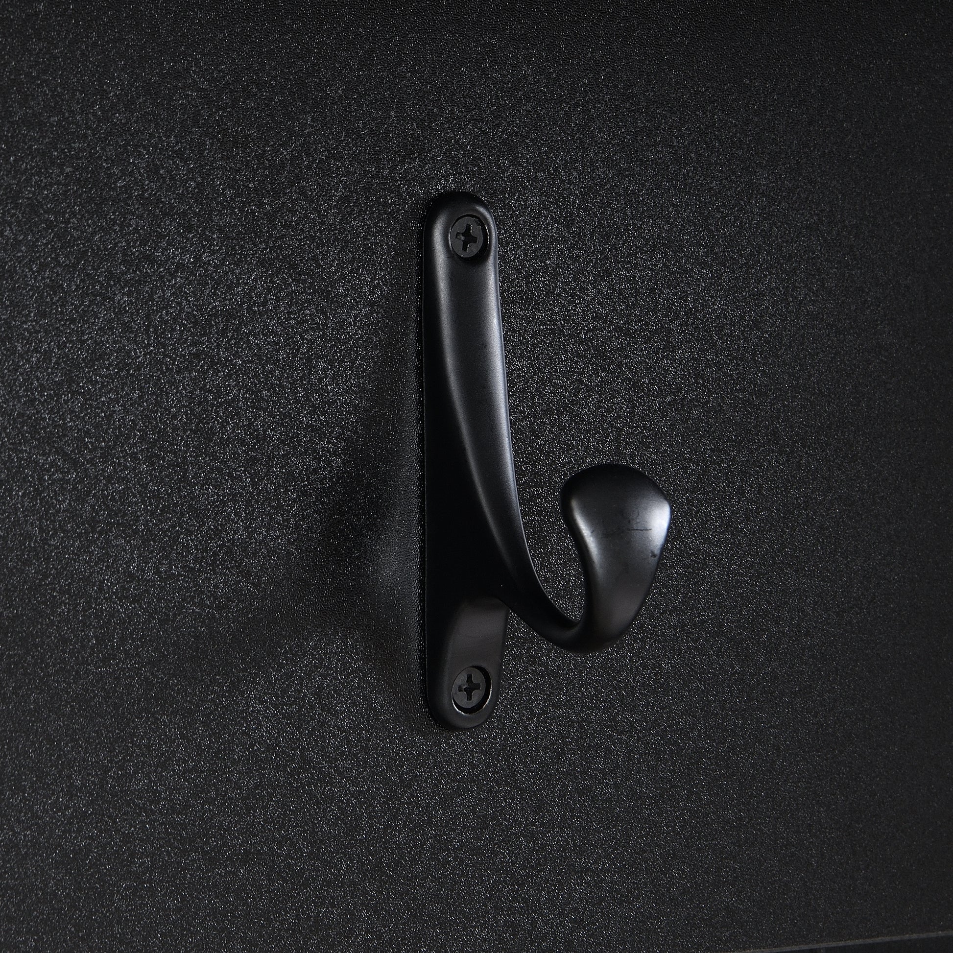 Matte black metal coat hook with rounded ends mounted on textured black surface