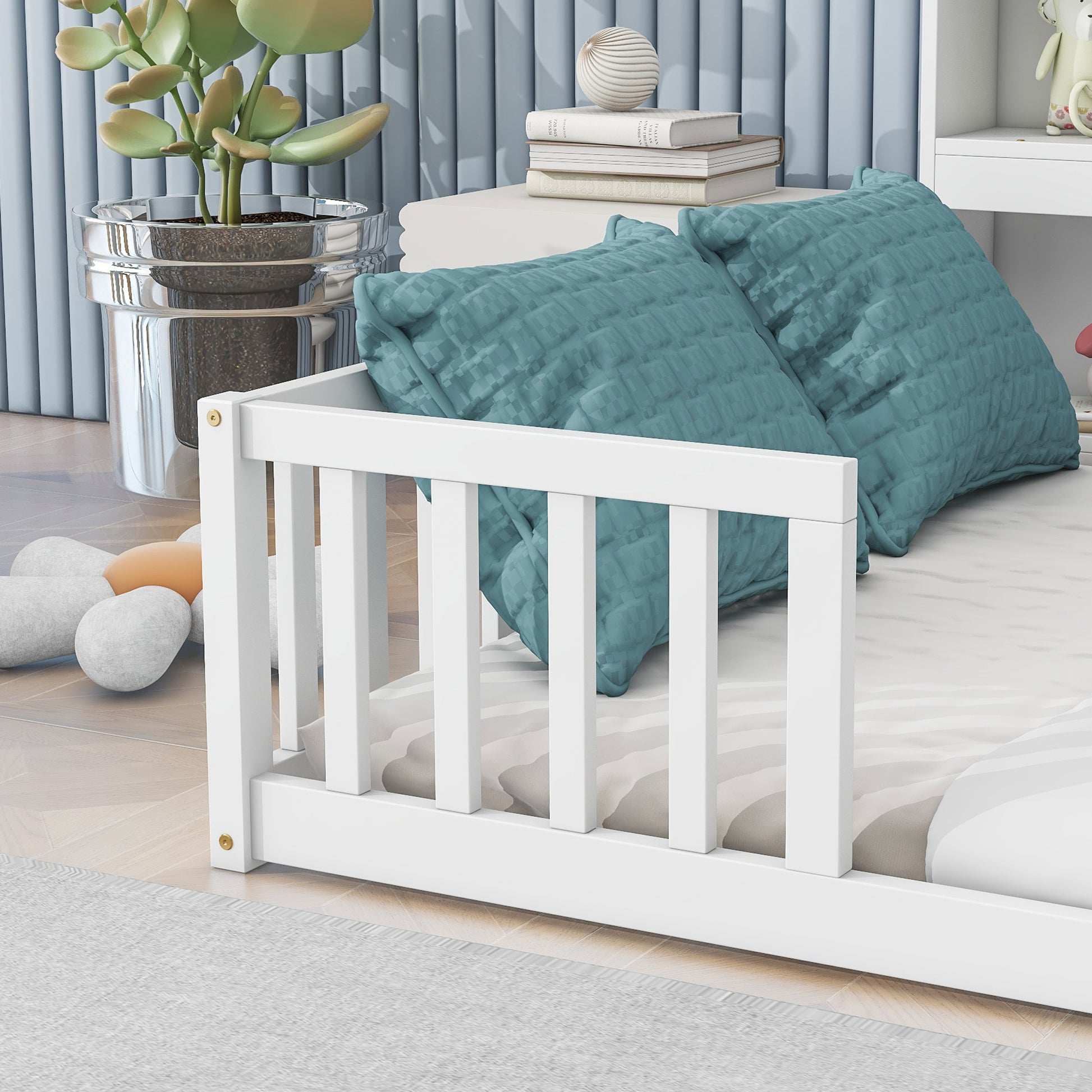 White wooden toddler bed rail with turquoise pillows and striped bedding