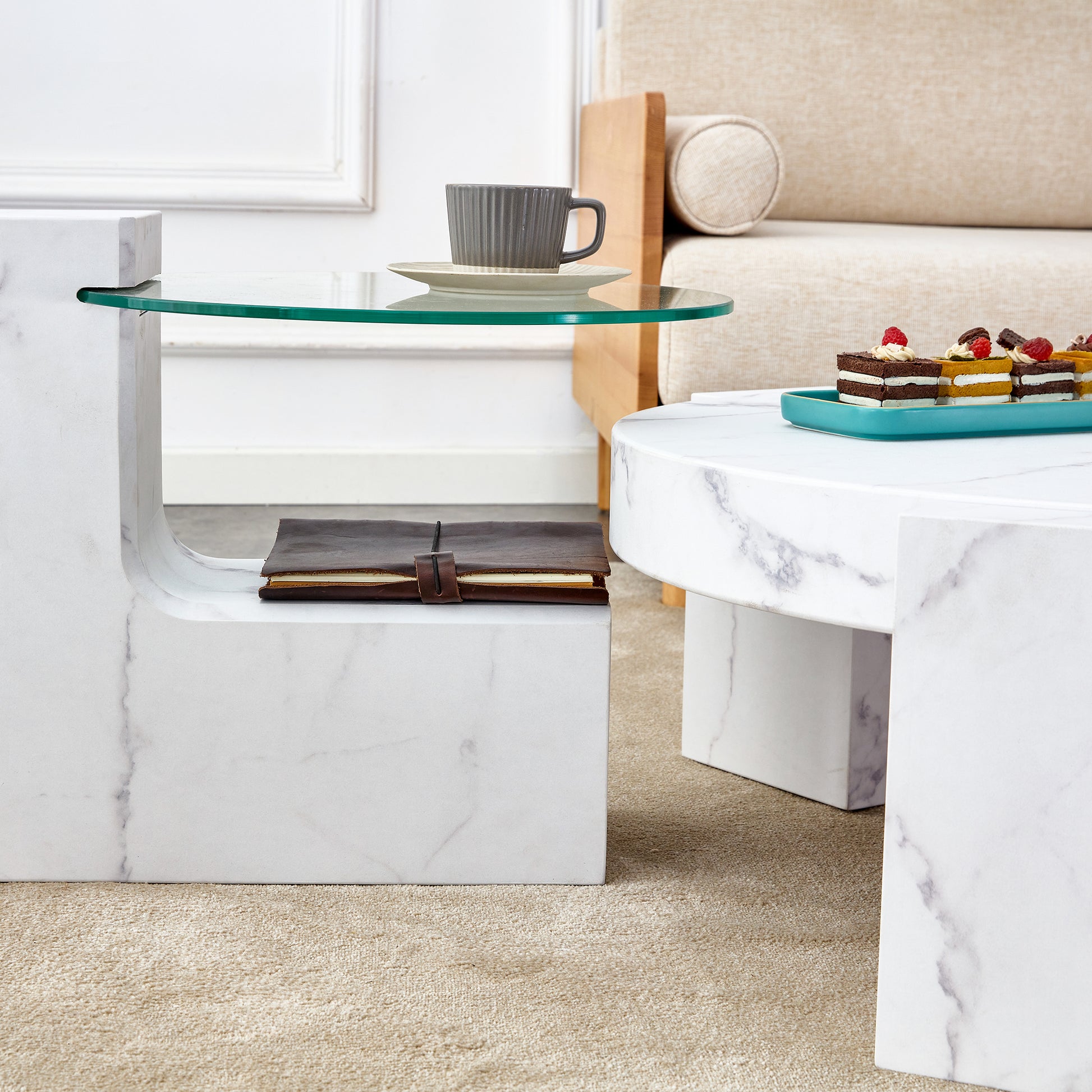 White marble side table with a glass shelf holding a gray coffee mug