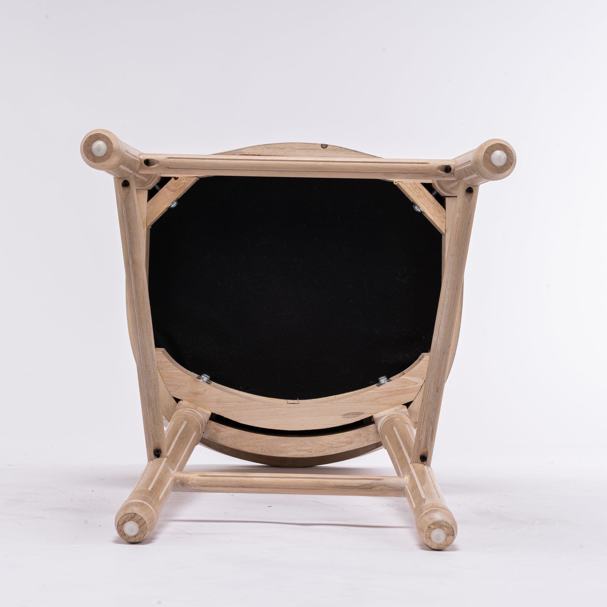 Under view of a distressed oak dining chair with black upholstered seat
