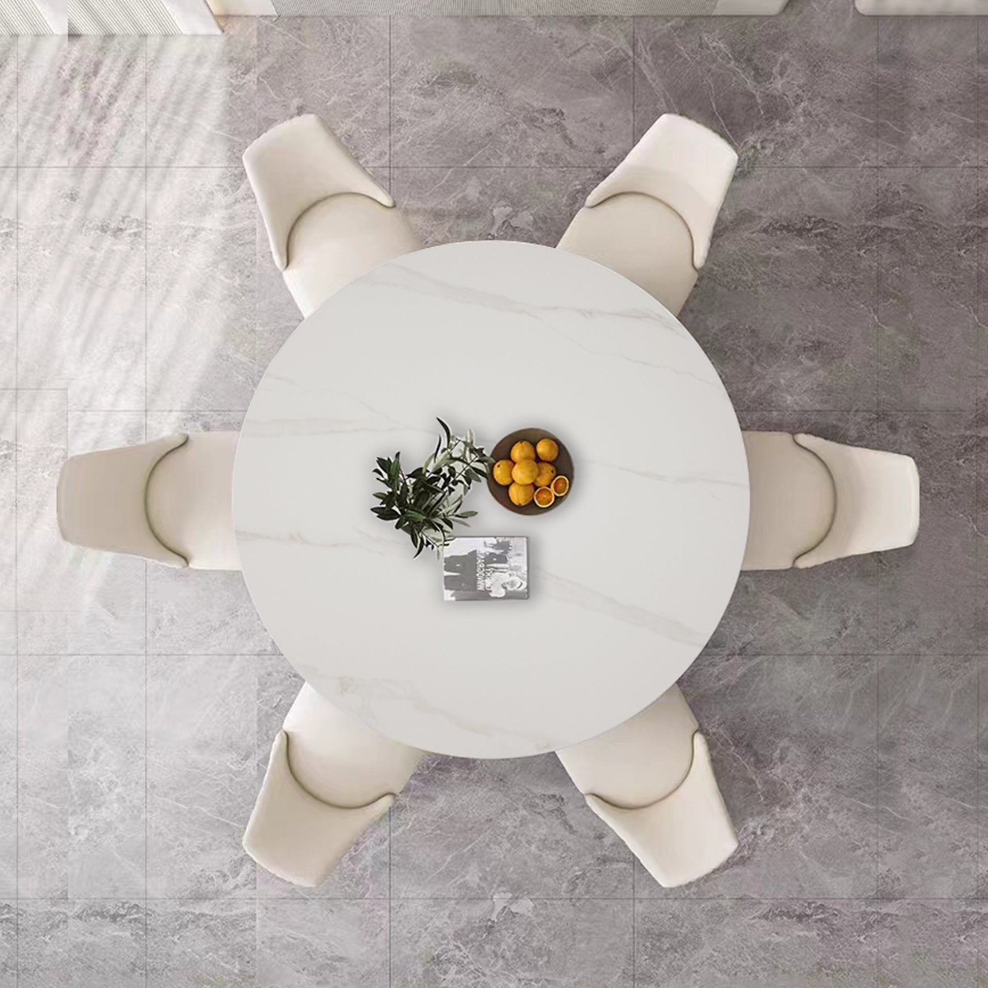 Round white marble dining table with six cream upholstered chairs