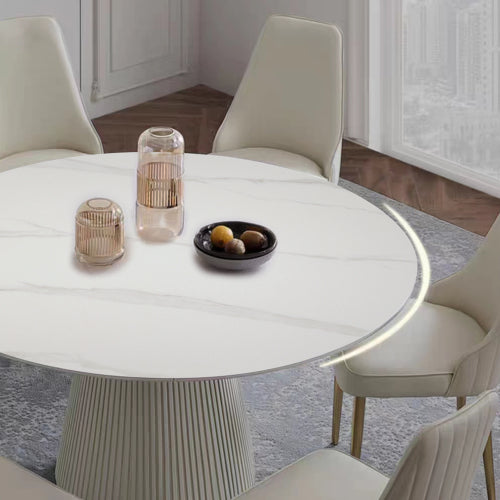 White marble dining table with fluted base and decorative vases