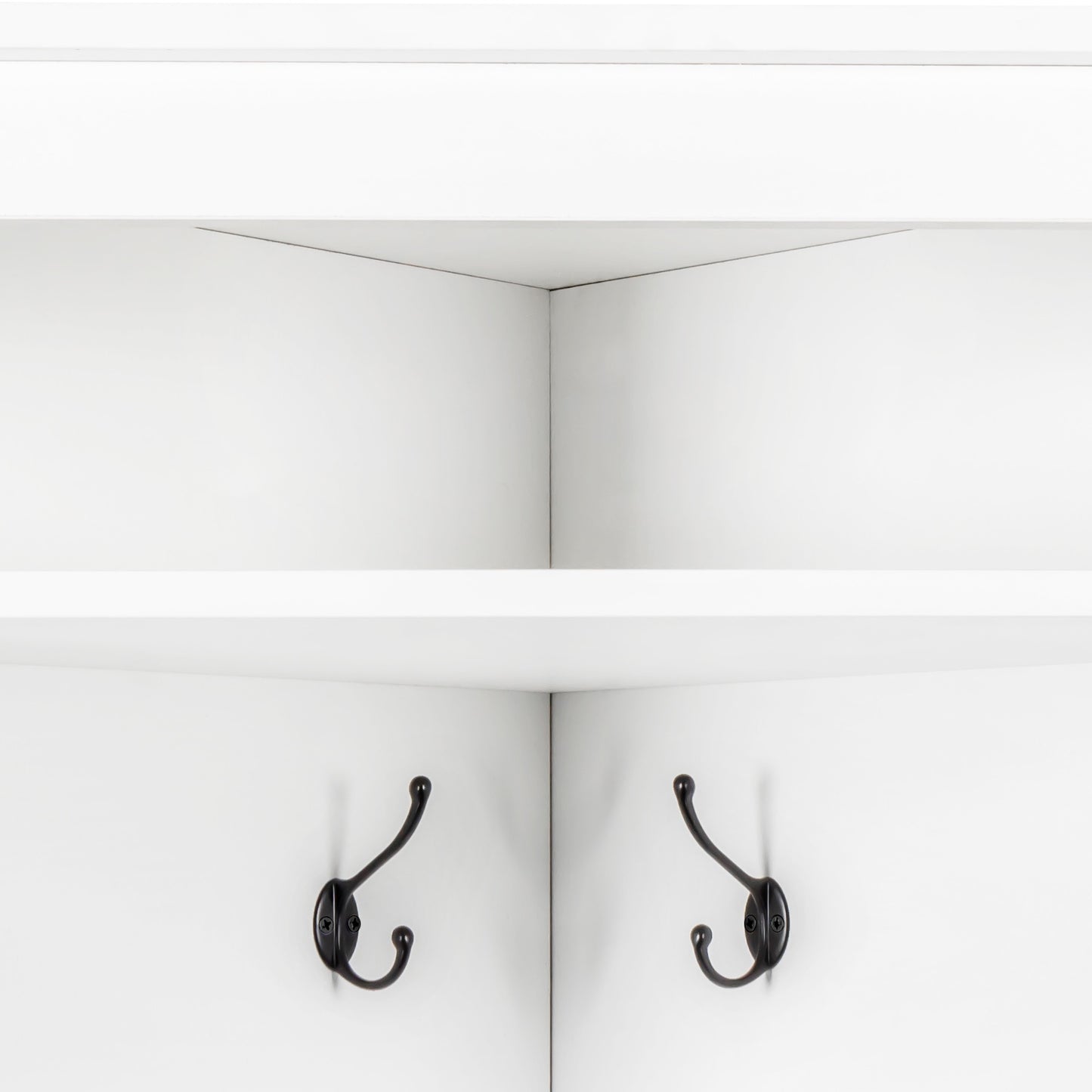 Classic bronze coat hooks mounted on white wall