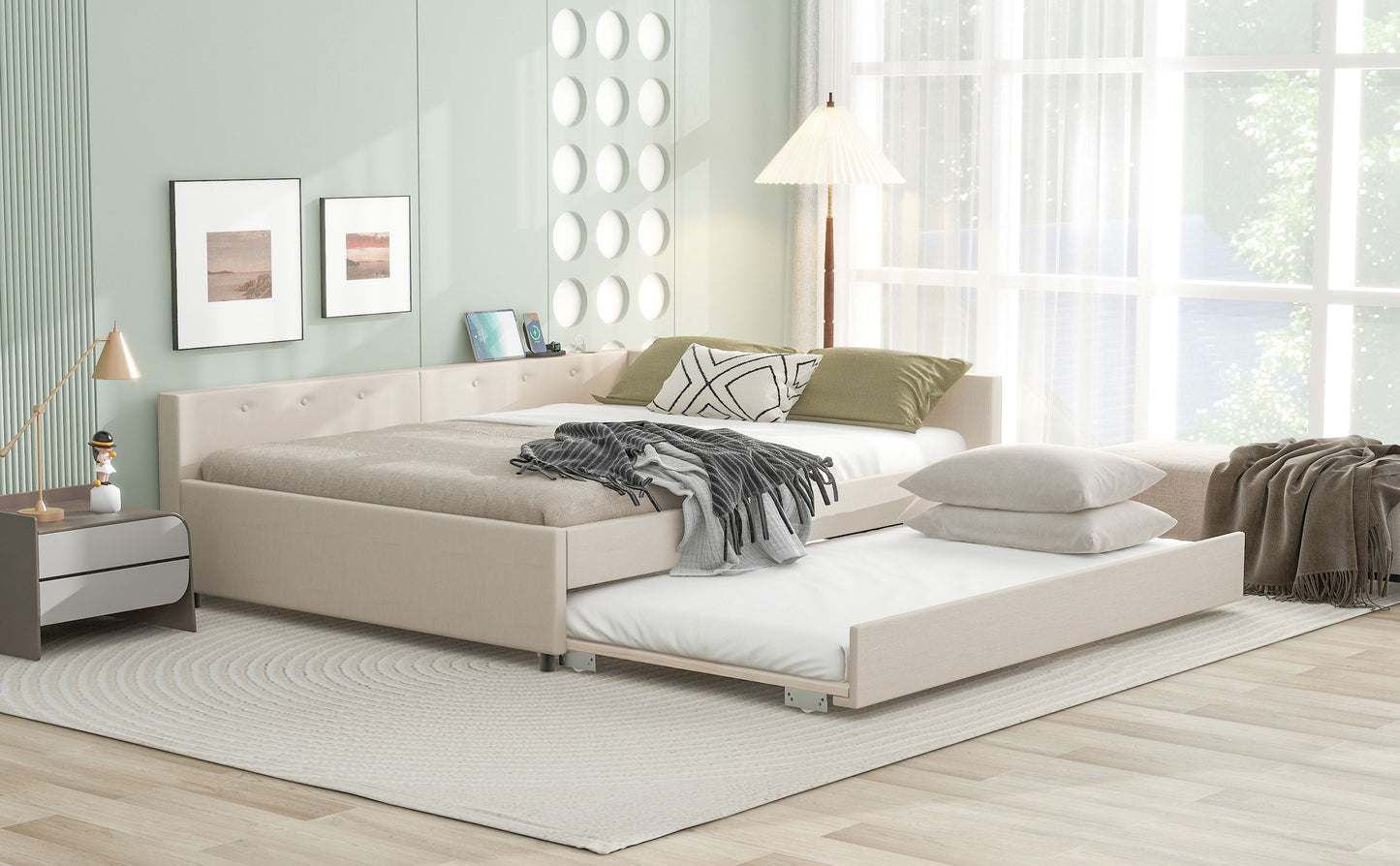 Beige upholstered daybed with trundle pulled out featuring tufted headboard and neutral bedding