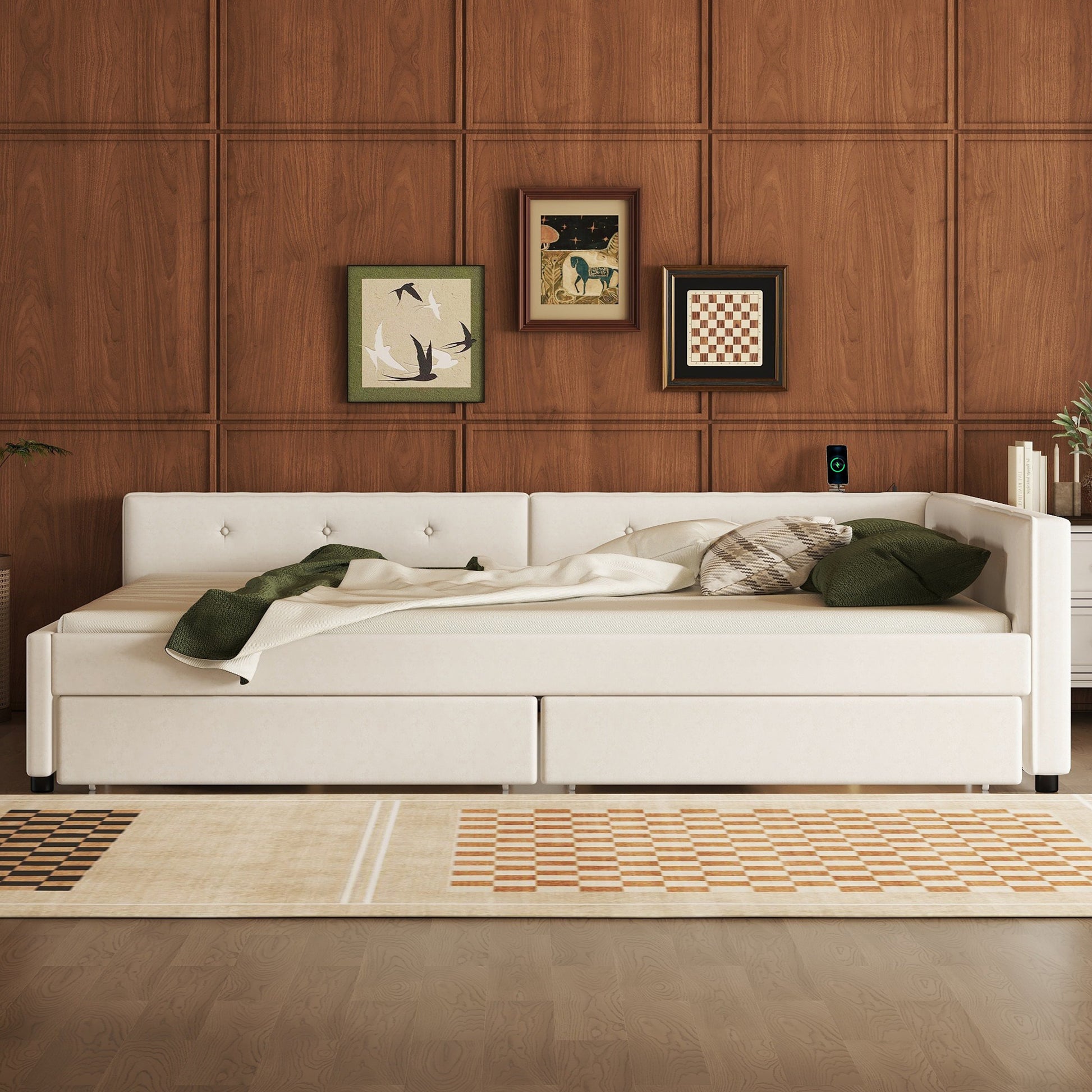 Tufted cream upholstered daybed with two drawers featuring green throw blanket and plaid pillows
