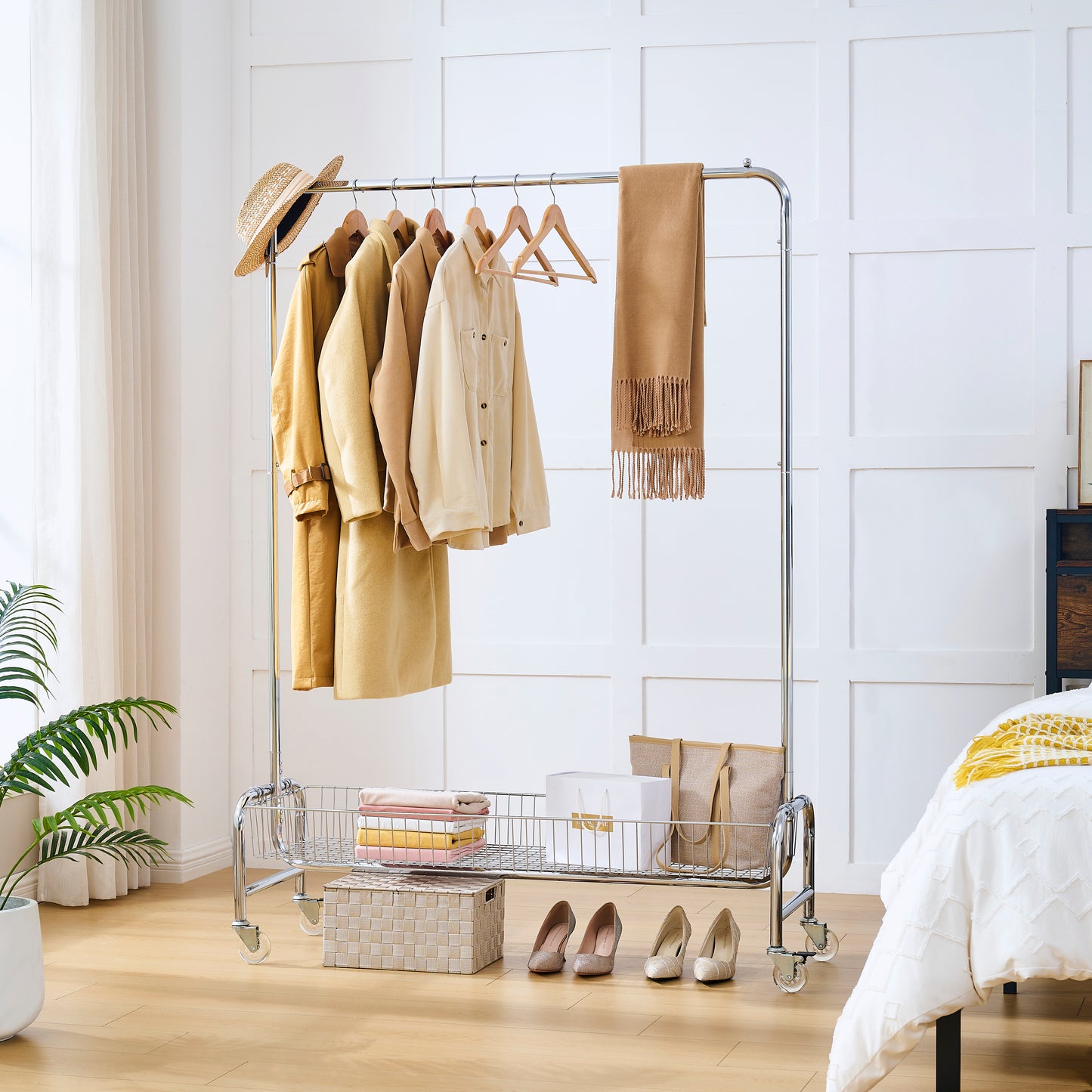 Chrome garment rack with beige coats and straw hat