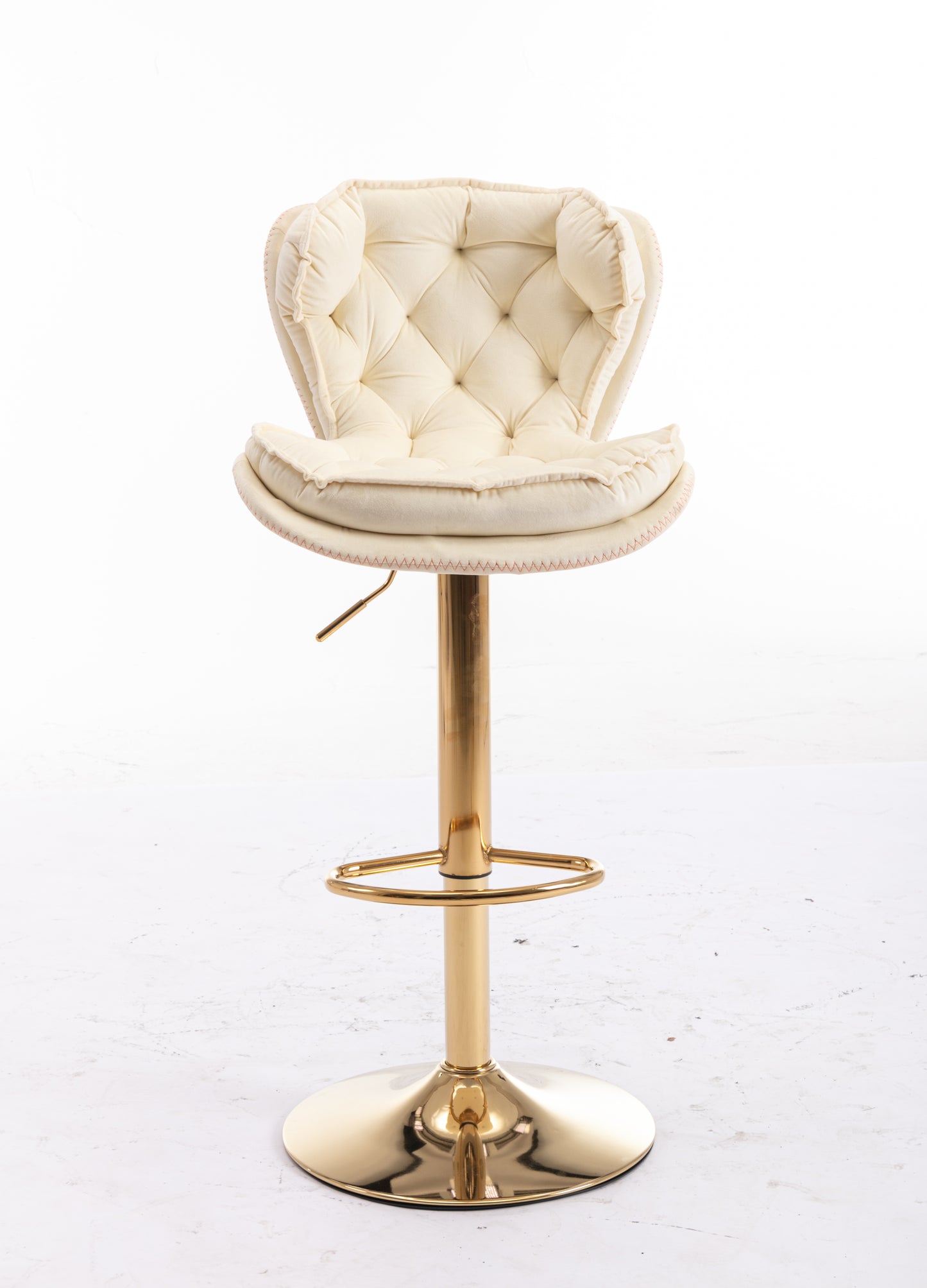Tufted cream velvet bar stool with gold pedestal base and footrest