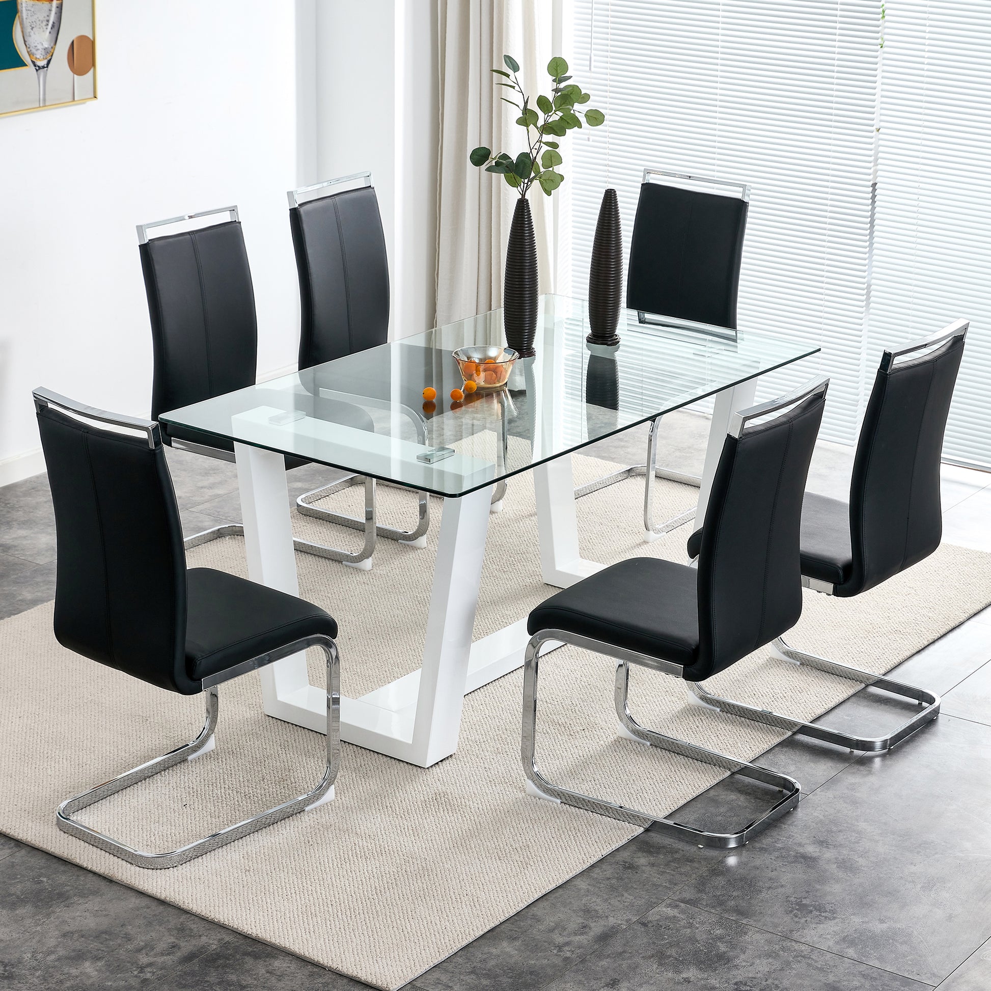 Glass top dining table with white base and six black faux leather chairs