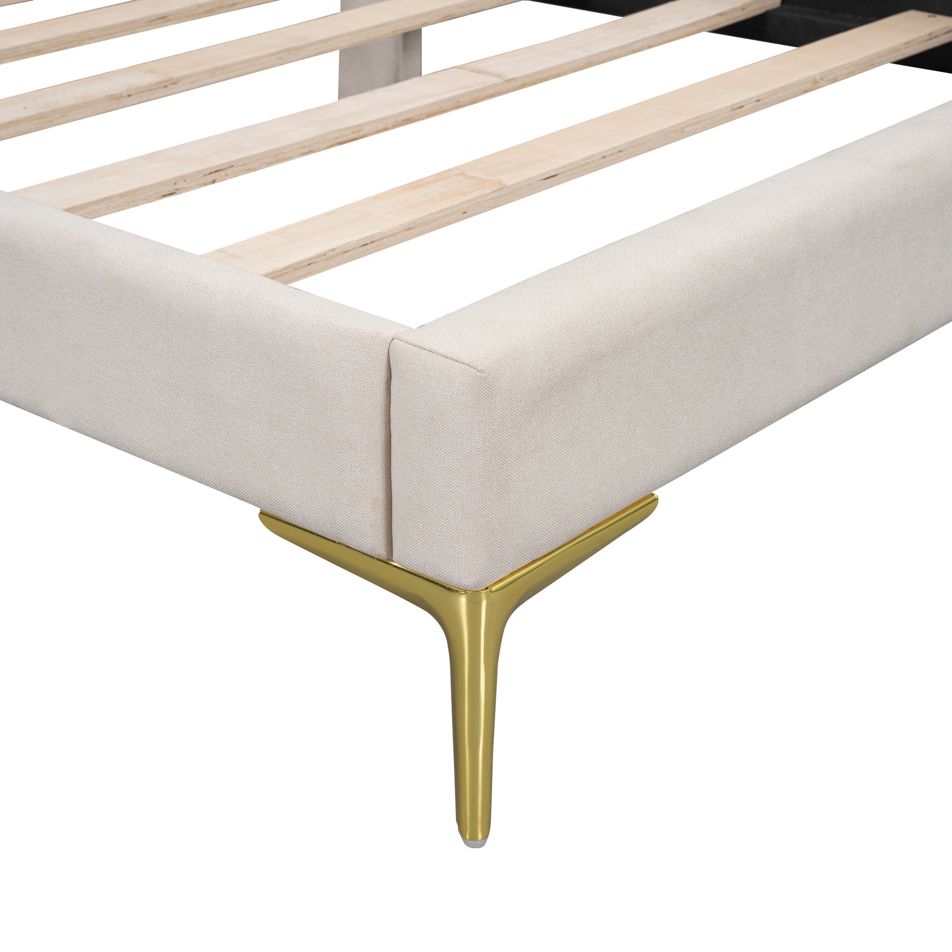 Closeup of beige upholstered bed frame corner with gold metal leg