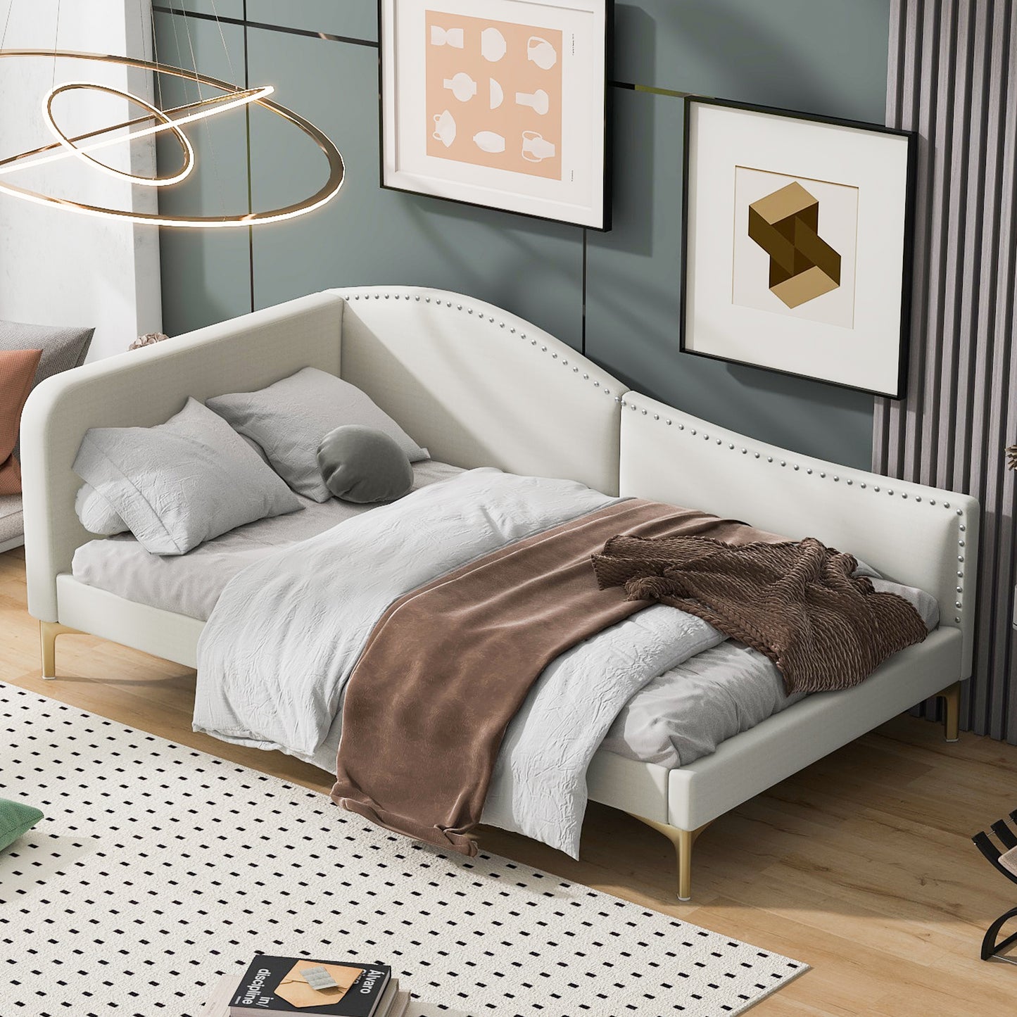 White upholstered daybed with studded trim and gold legs