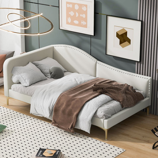 White upholstered daybed with studded trim and gold legs