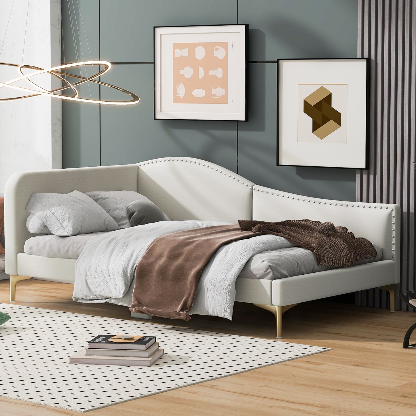 Cream upholstered daybed with gold legs and silver nailhead trim