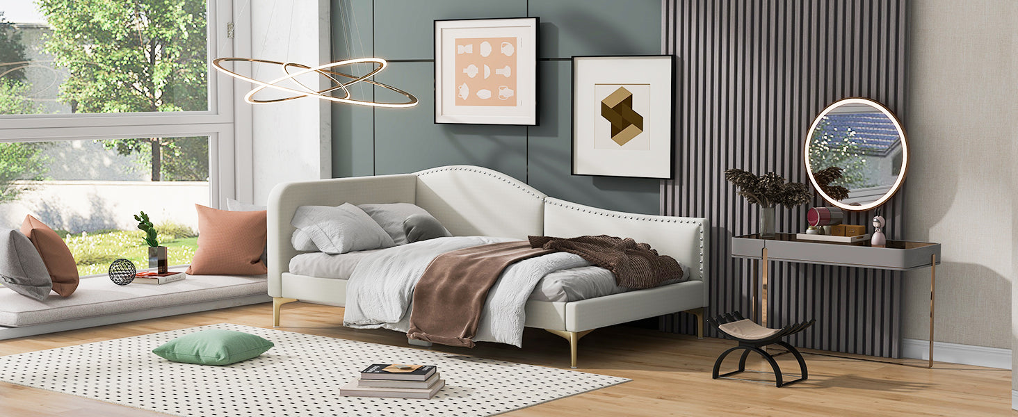 White upholstered daybed with gold legs and brown throw blanket