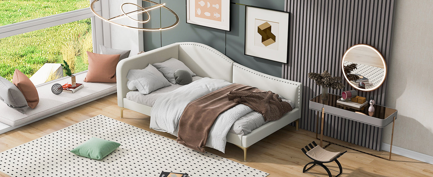 White upholstered daybed with gold legs and scattered pillows