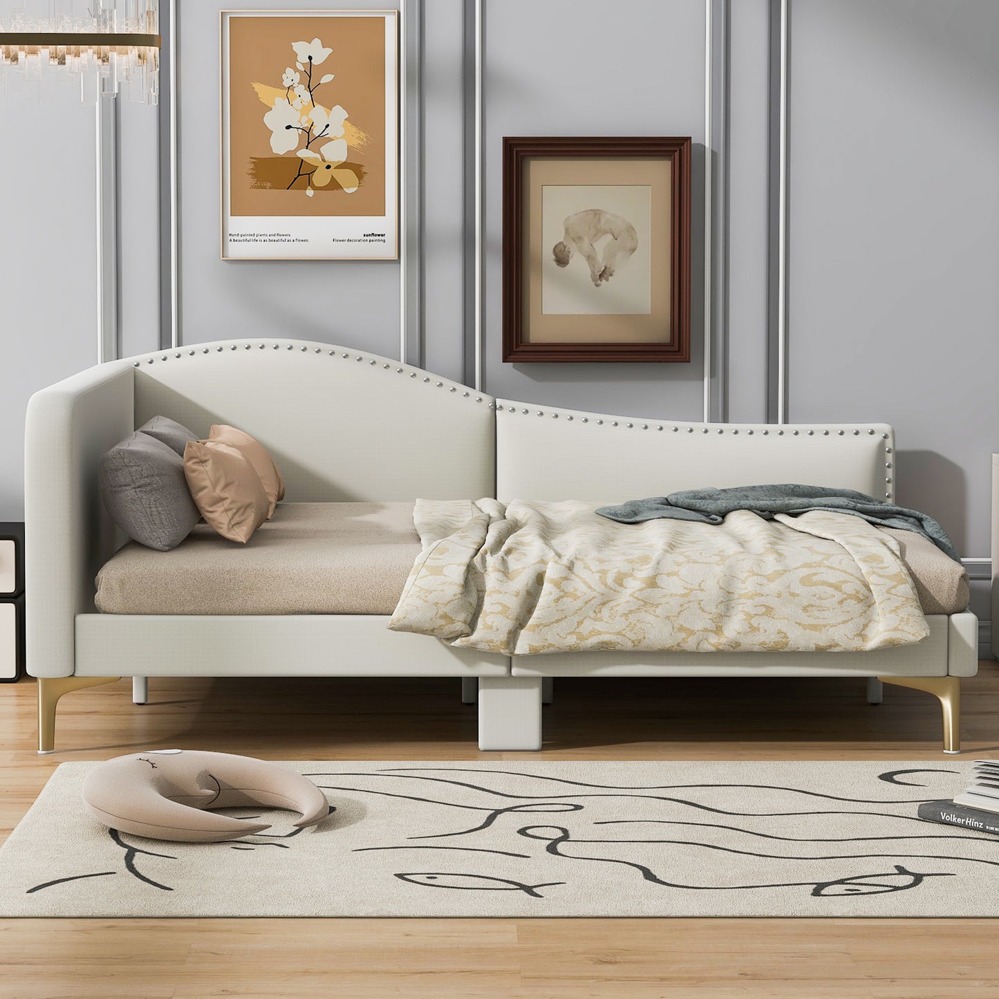 Cream upholstered daybed with silver nailhead trim and gold legs
