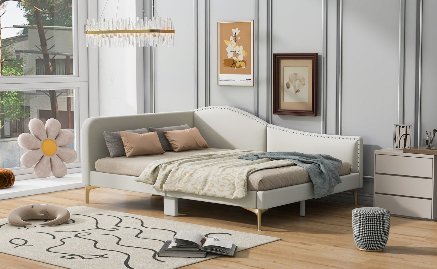 White upholstered daybed with decorative nailhead trim and gold legs
