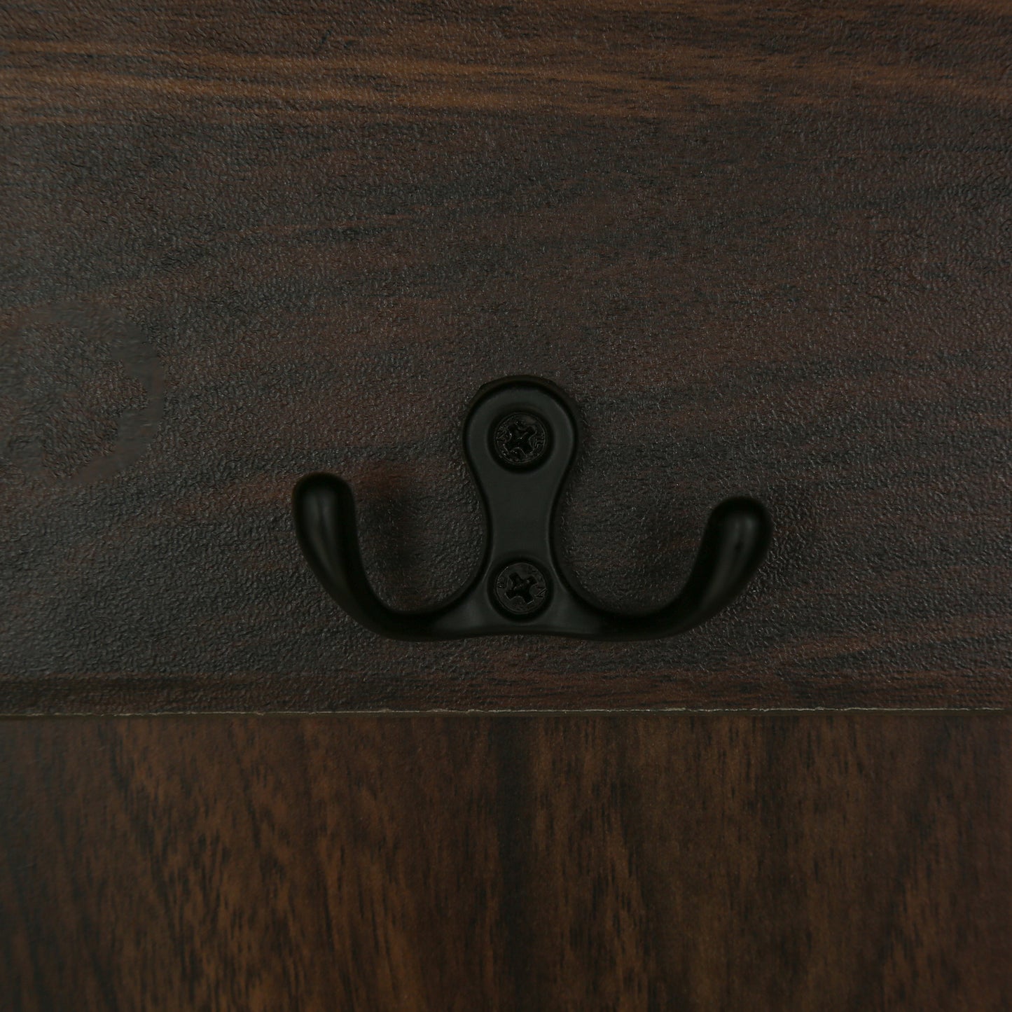 Dark brown wooden wall panel with a black double coat hook