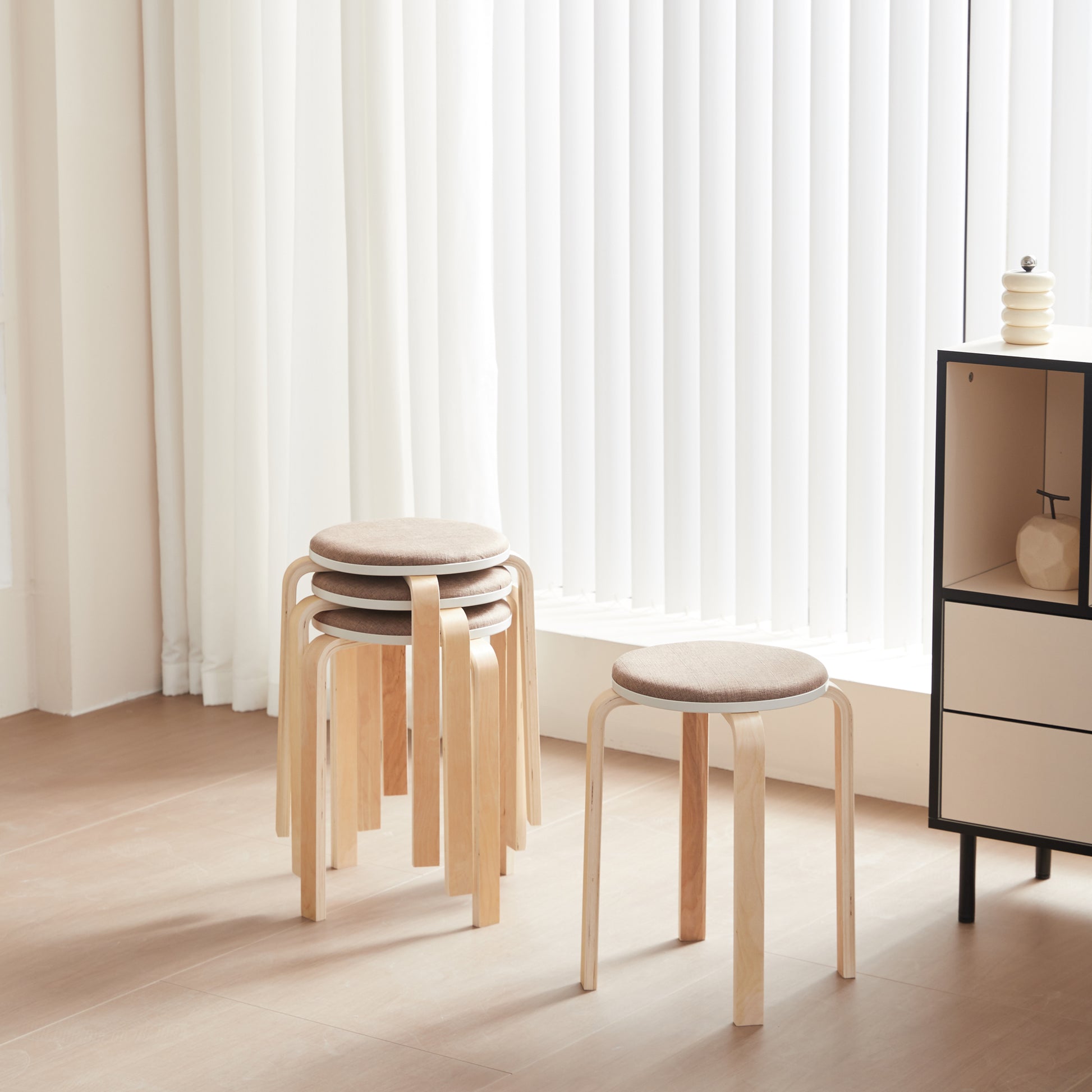 Stacking wooden stools with light brown upholstered seats