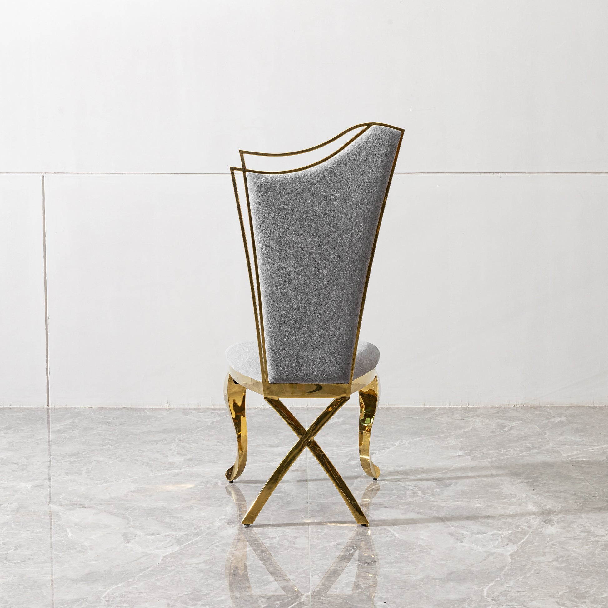 Grey upholstered dining chair with polished gold frame legs