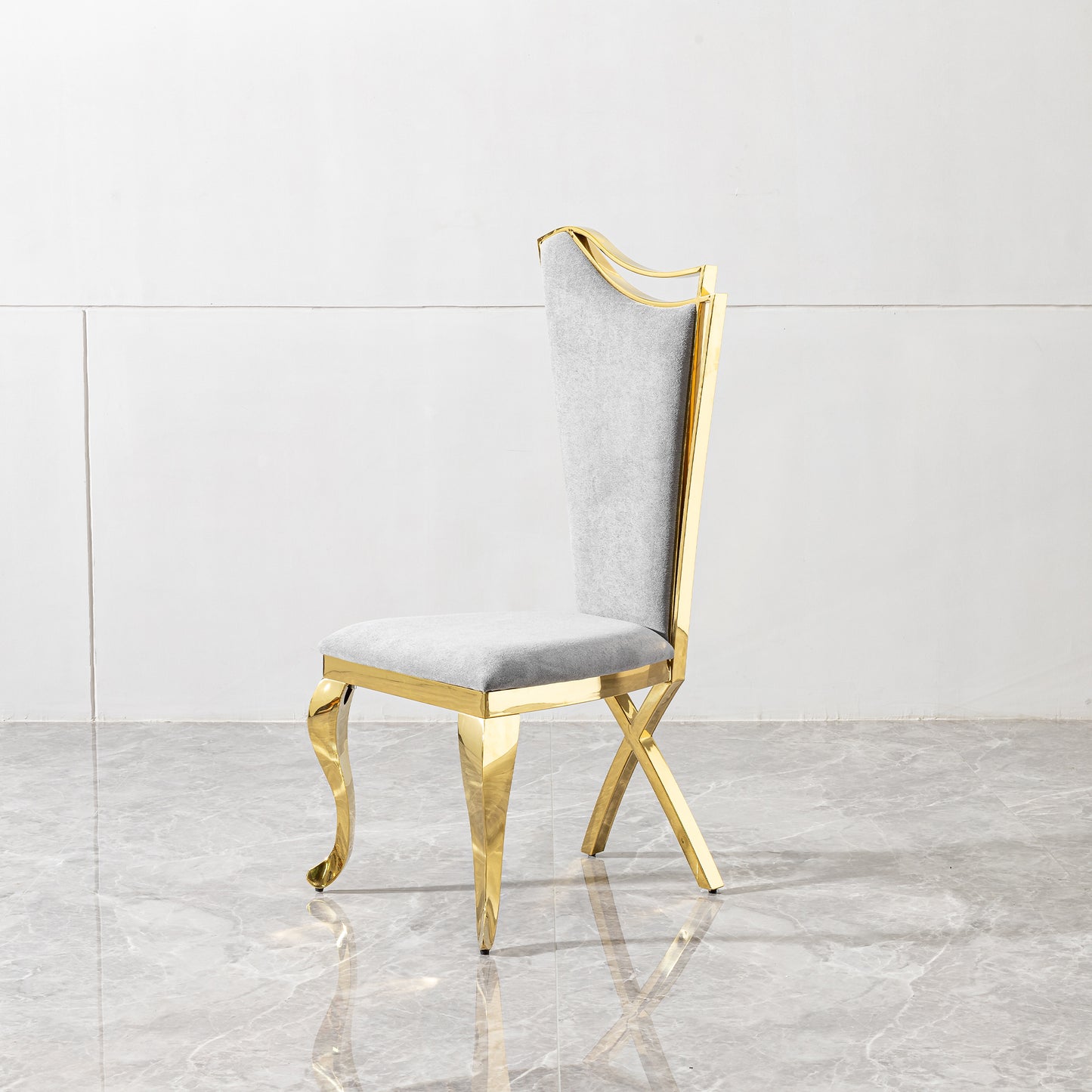 Elegant grey upholstered dining chair with polished gold frame and decorative legs