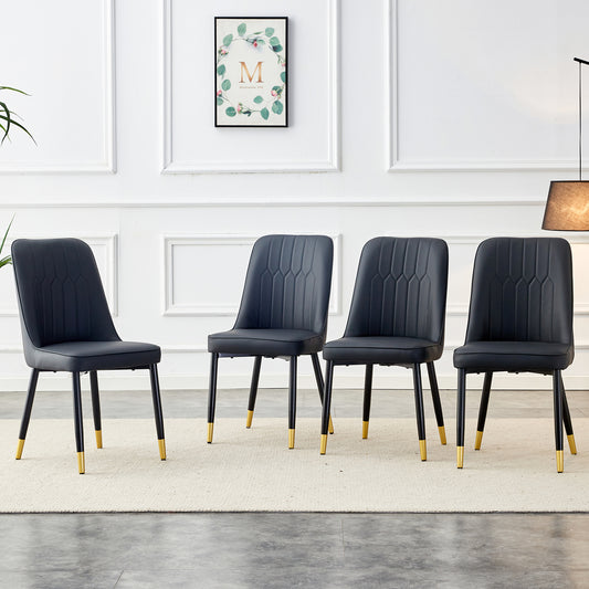 Four black faux leather dining chairs with goldtipped legs