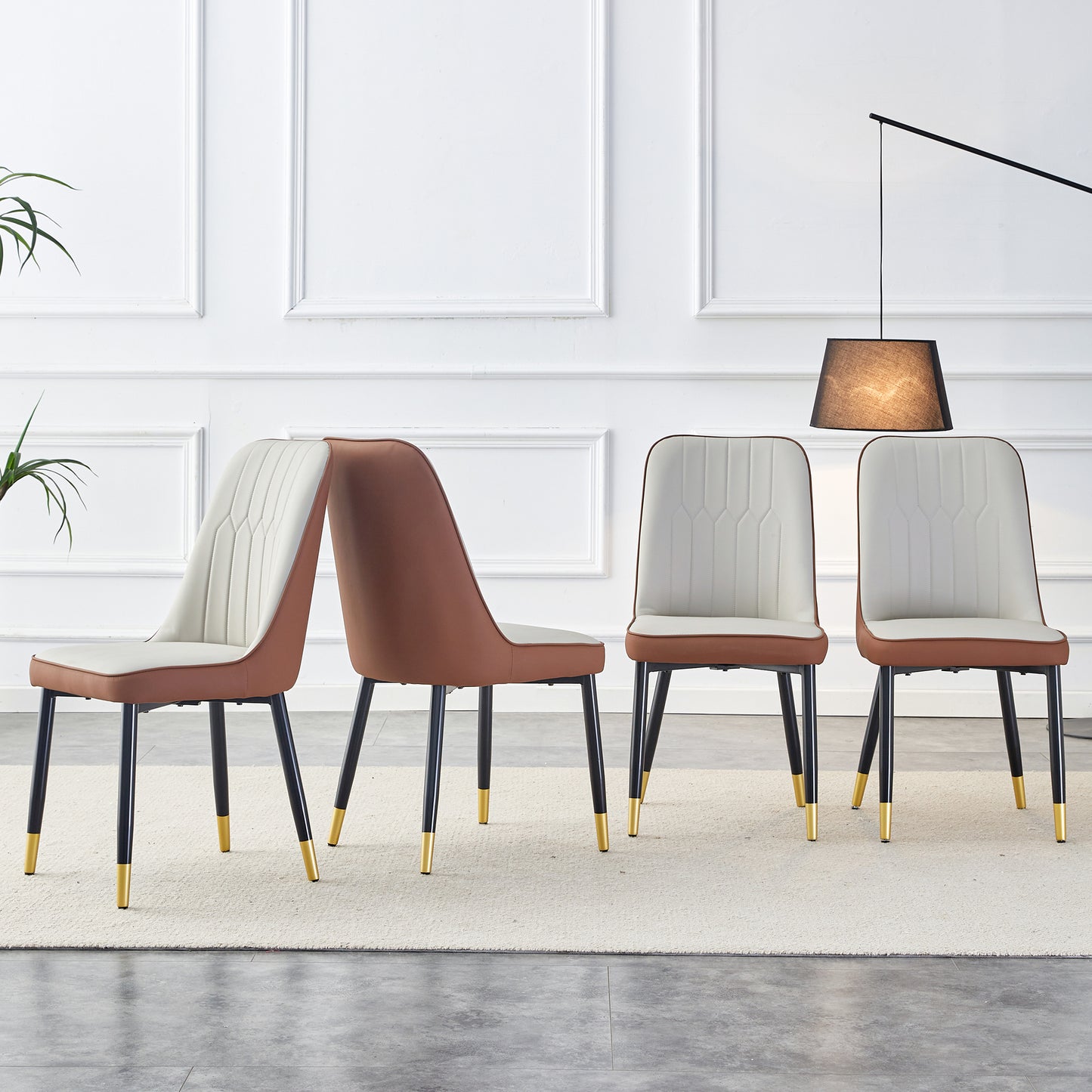Set of four brown and white upholstered dining chairs with goldtipped black legs