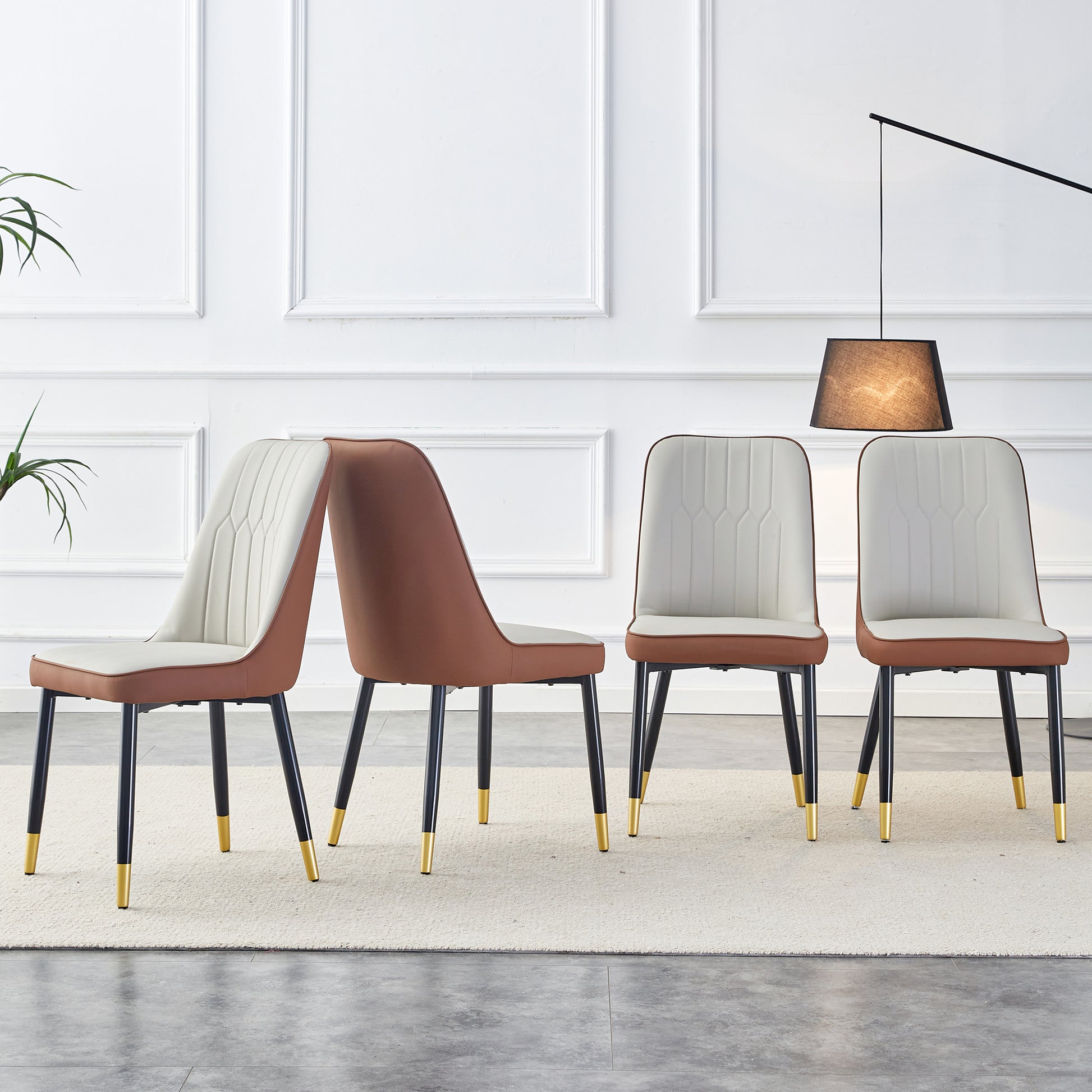 Set of four brown and white upholstered dining chairs with goldtipped black legs