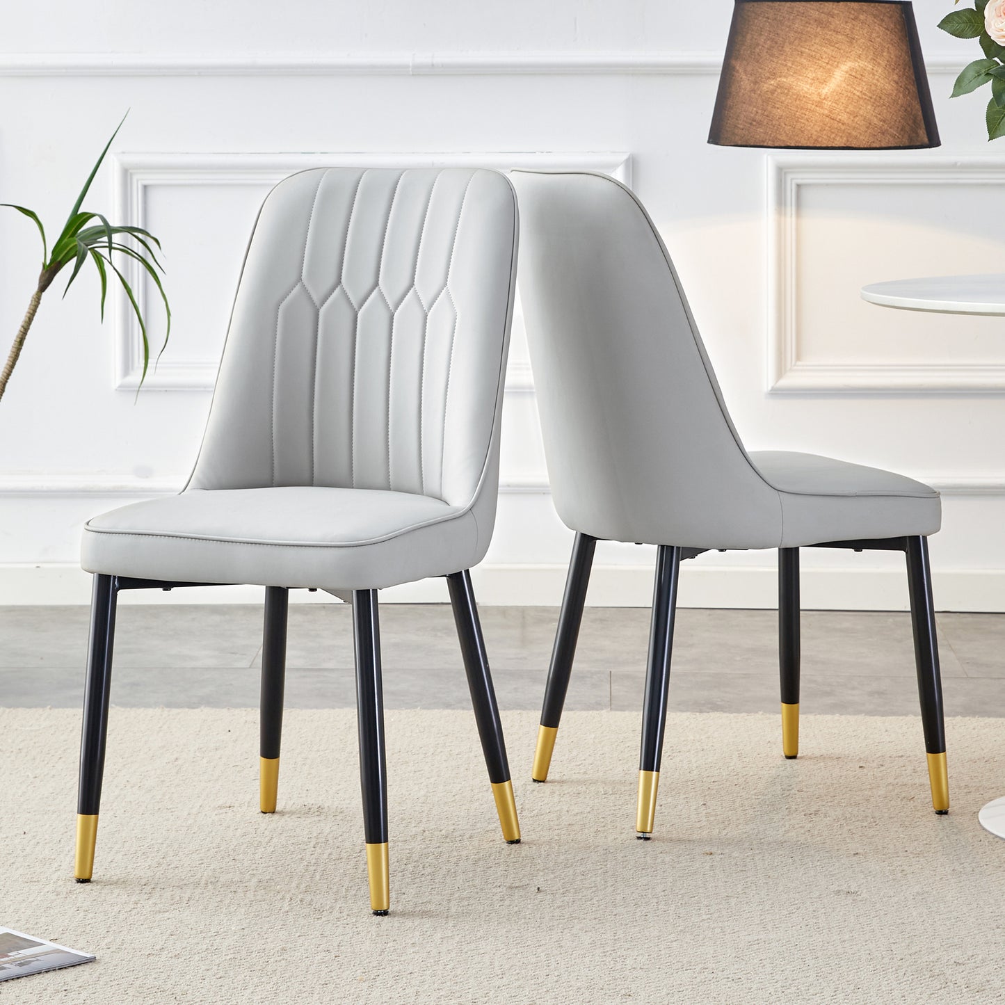 Modern gray dining chair with channel tufting and goldtipped black legs