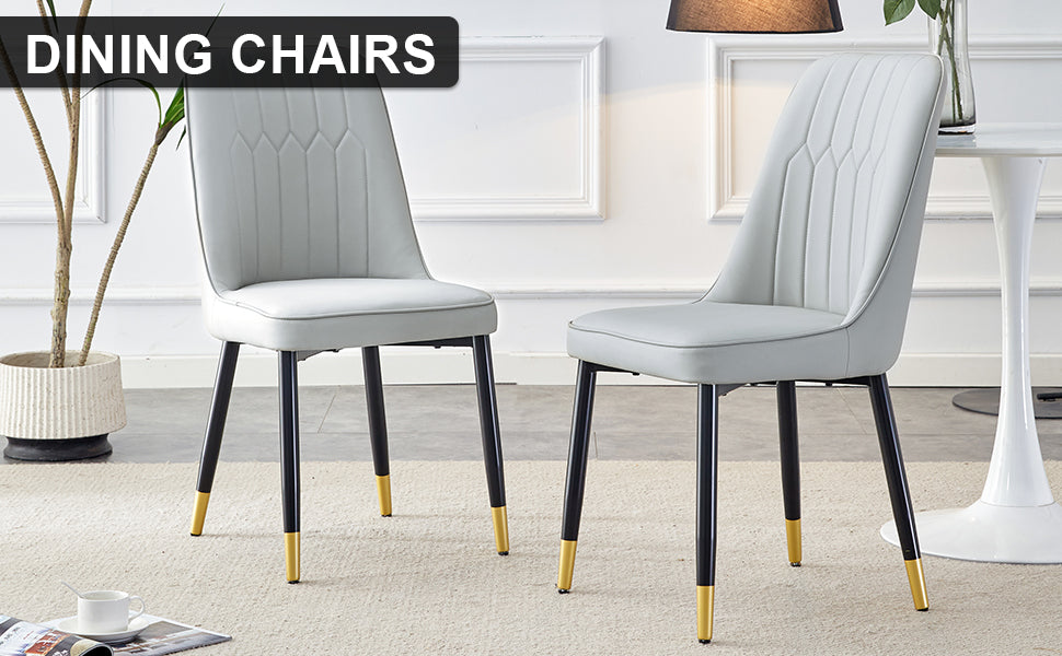 Light gray tufted dining chairs with black and gold legs