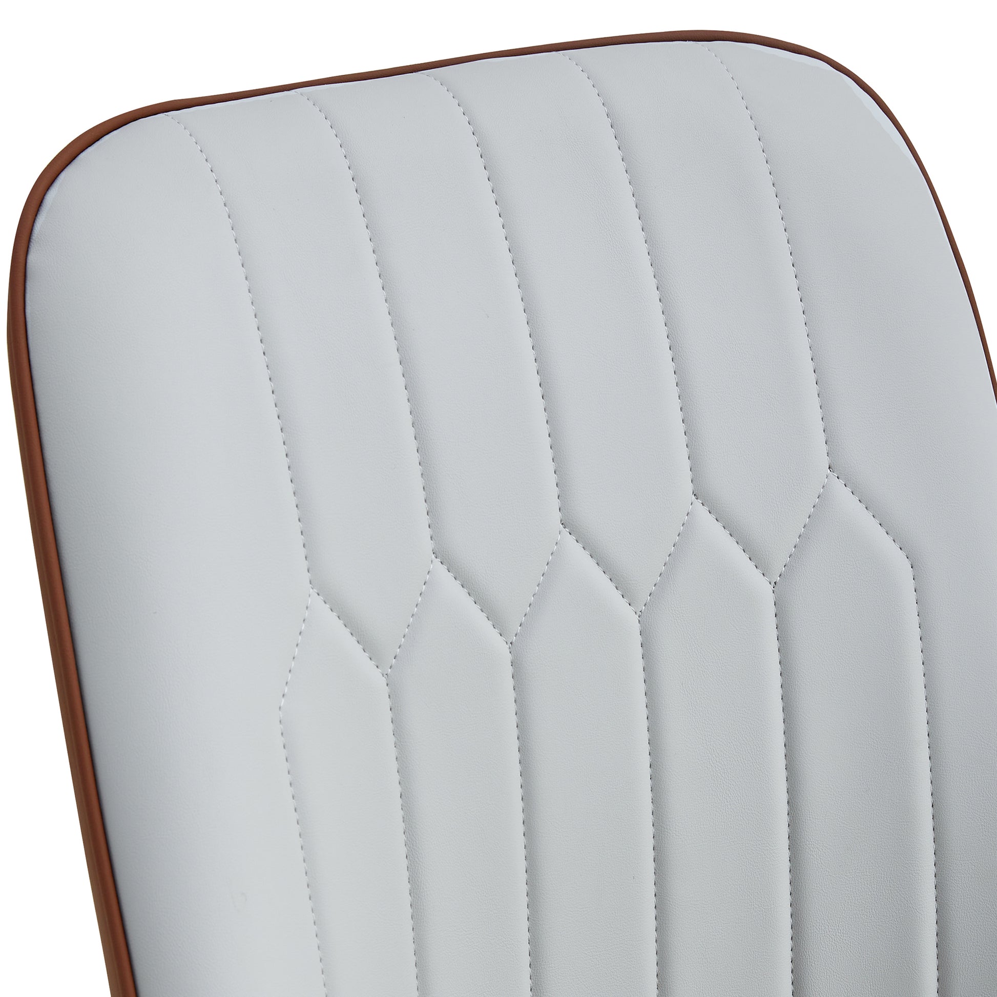 Closeup of white upholstered chair back with diamond stitching and brown piping