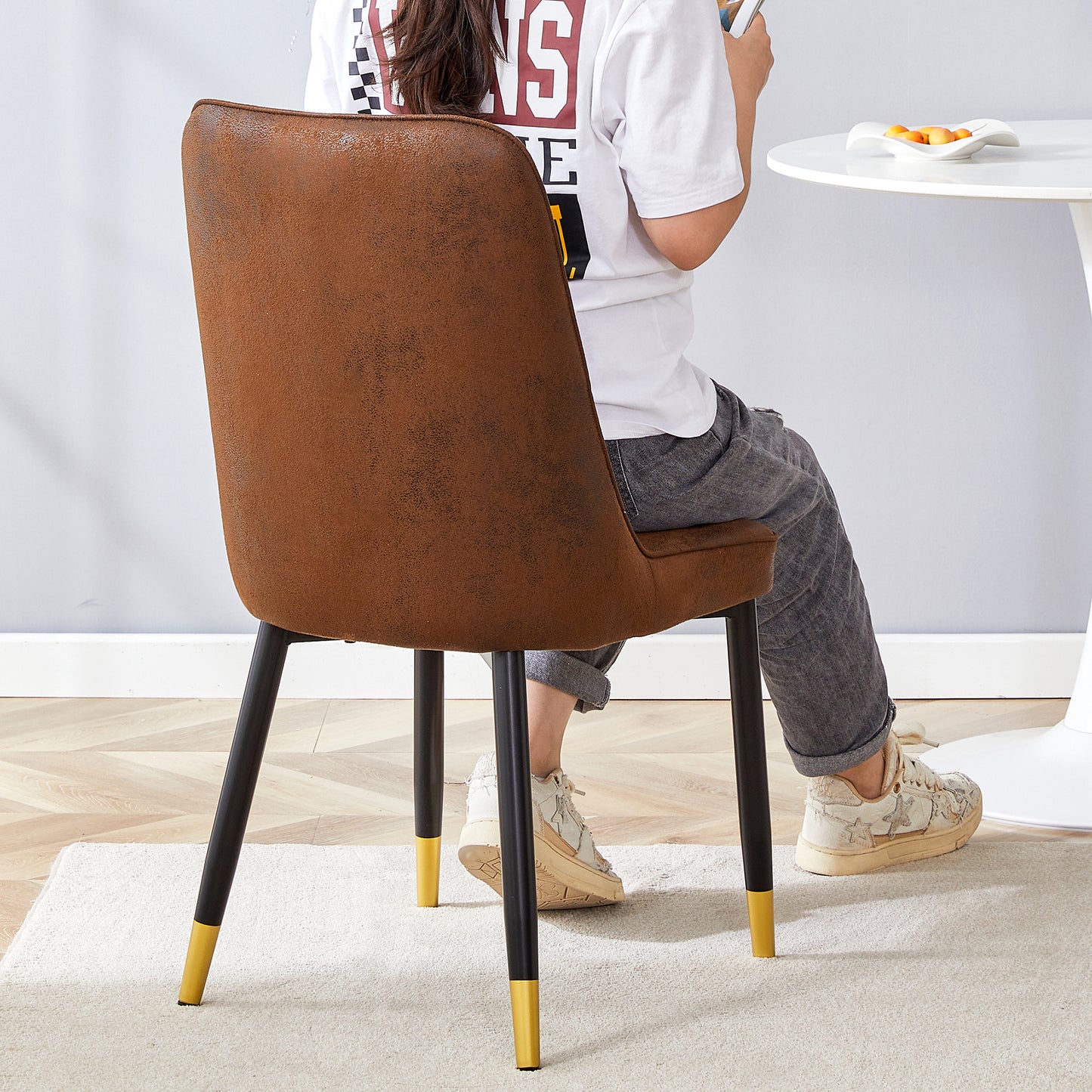 Brown faux leather dining chair with black metal legs and gold accents