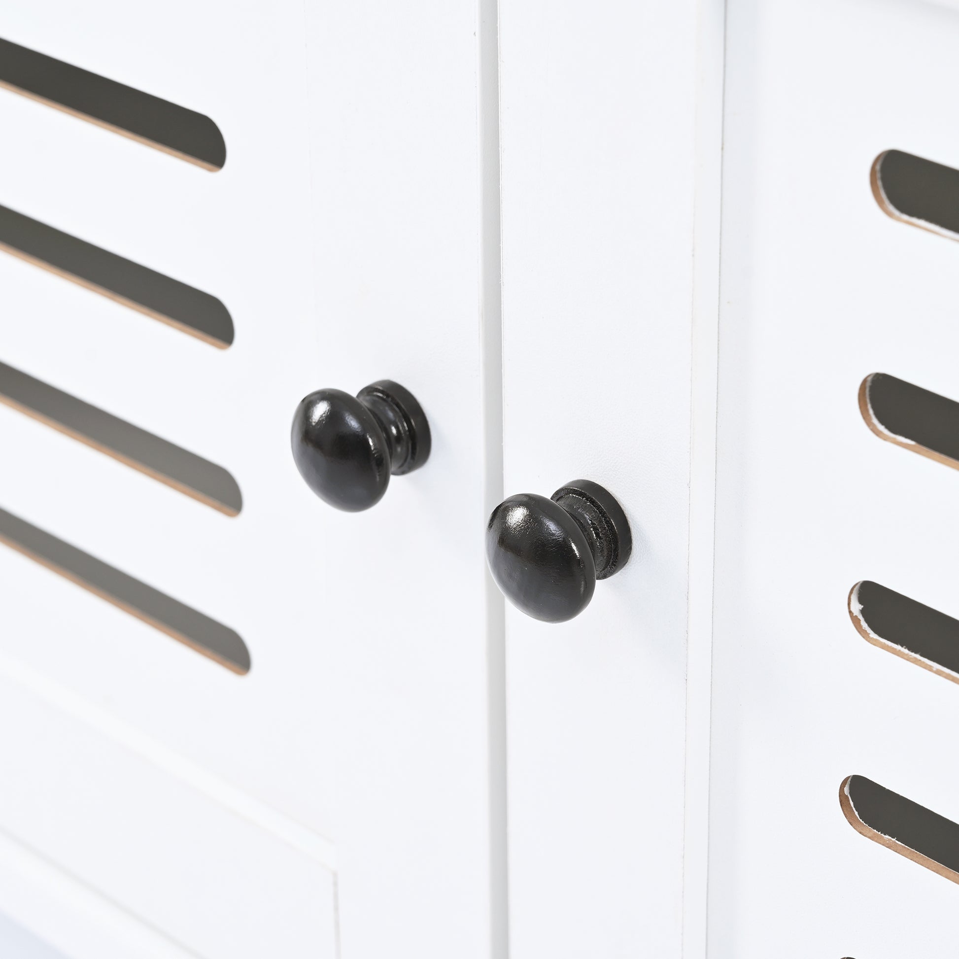 White cabinet door with black oval knobs and slatted detail
