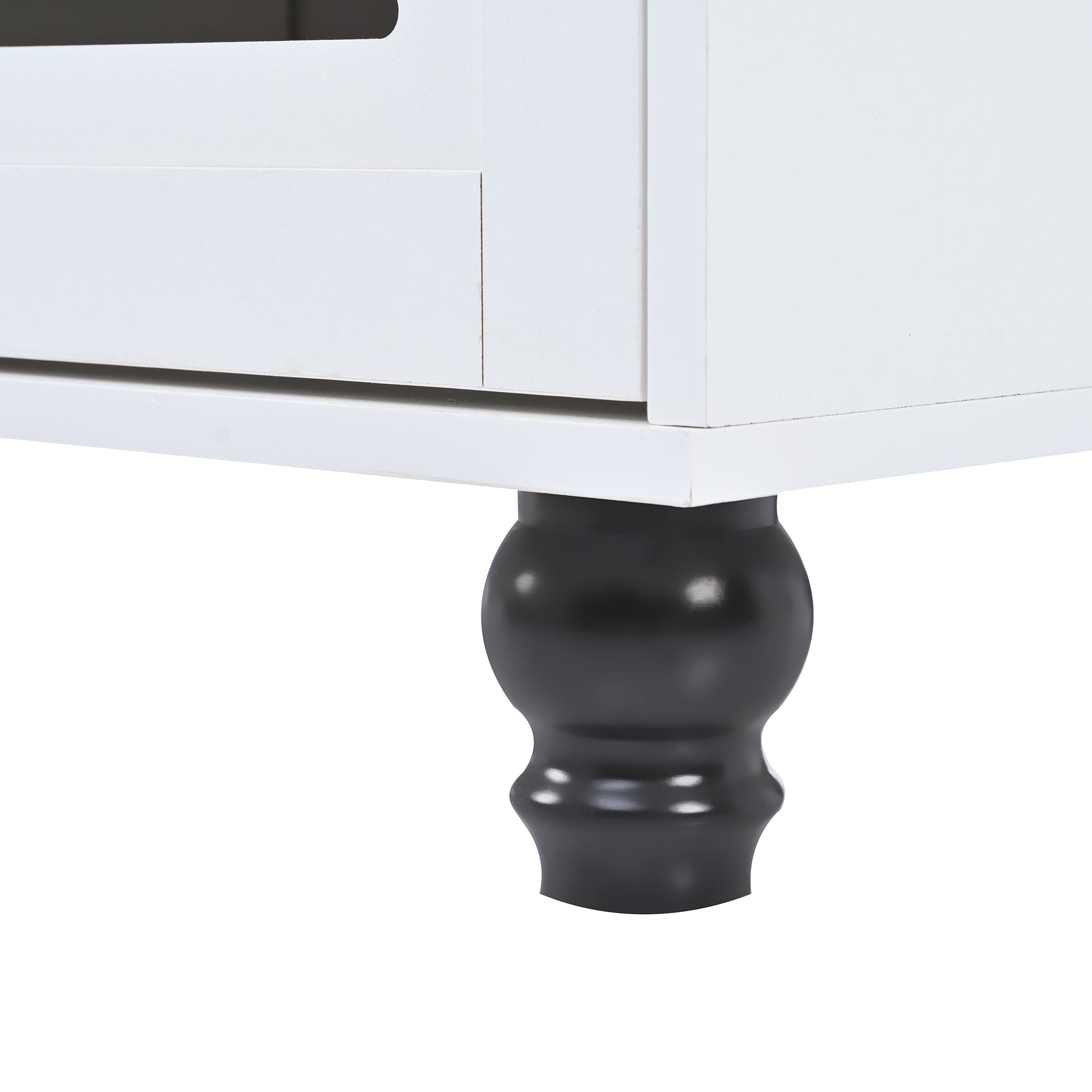 Closeup of a white wooden cabinet with a decorative black turned leg