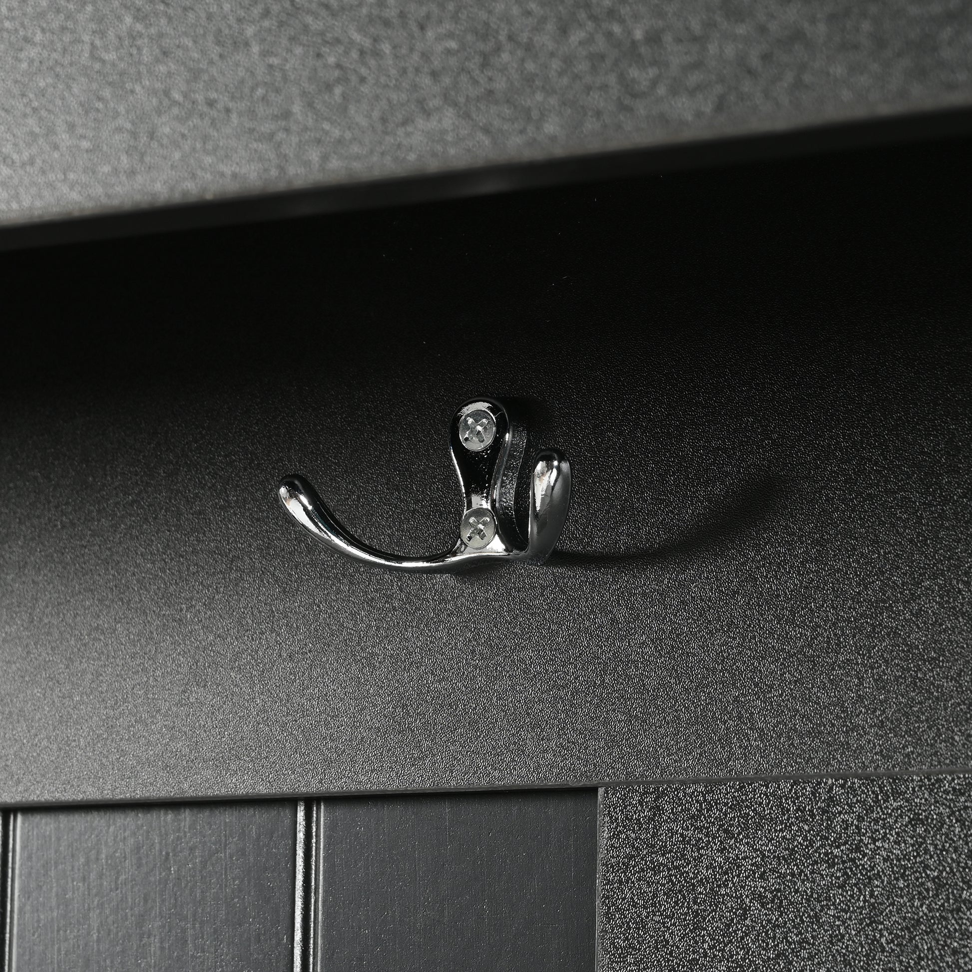 Chrome double hook mounted on textured black panel