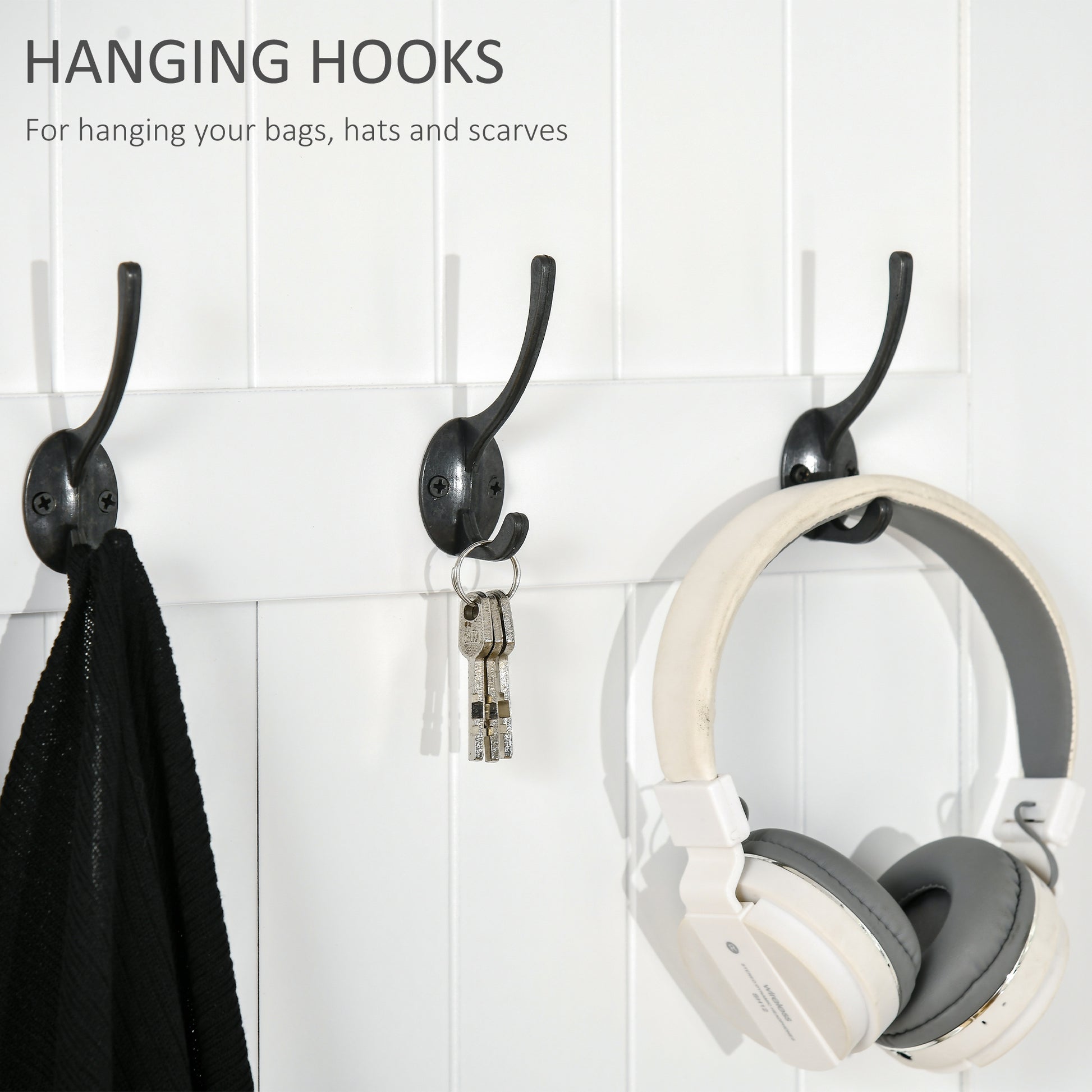 Three dark metal hanging hooks mounted on white beadboard wall holding a scarf keys and headphones