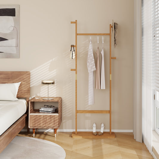 Natural wood garment rack with beige handbag and light dresses