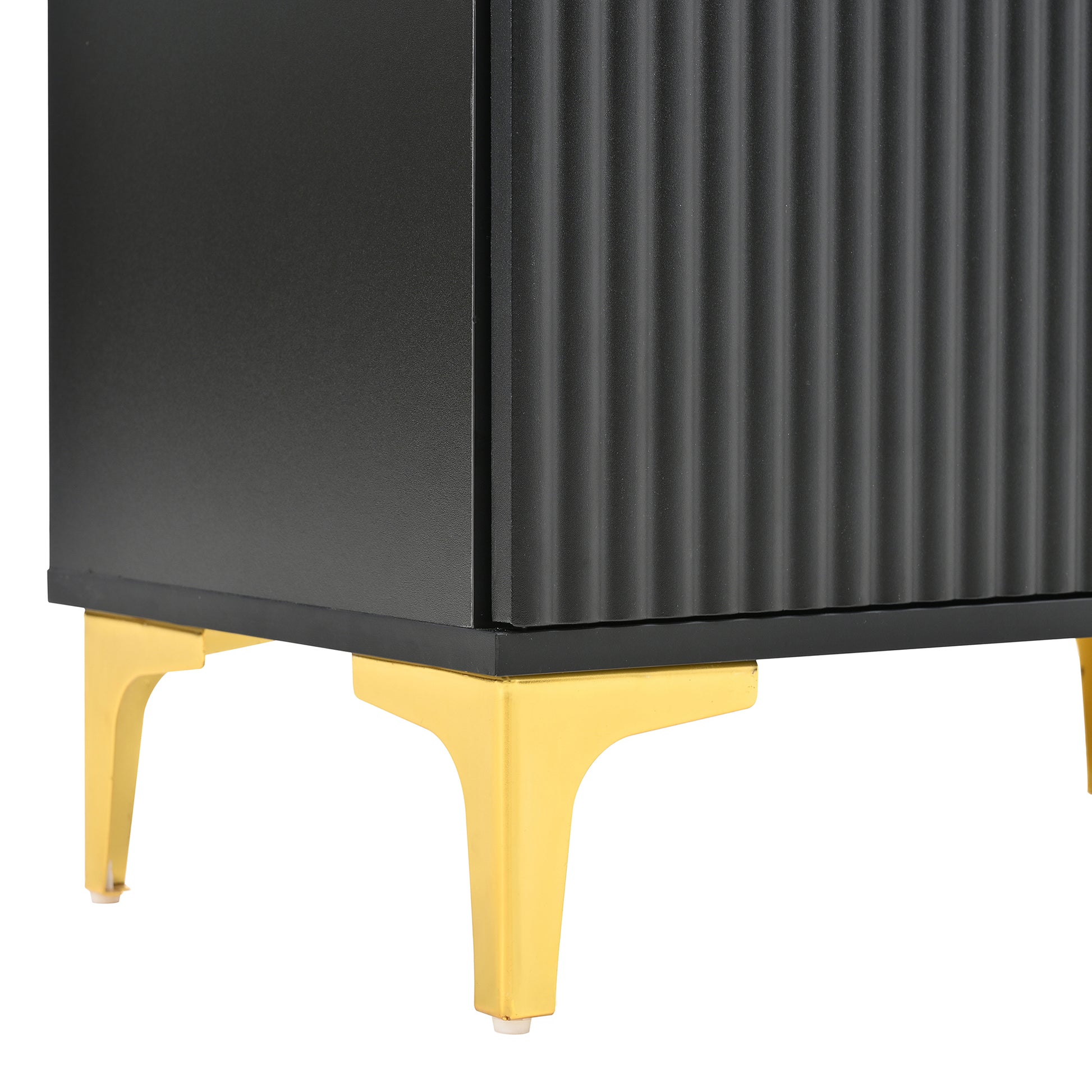 Black fluted cabinet door detail with angled gold metal legs