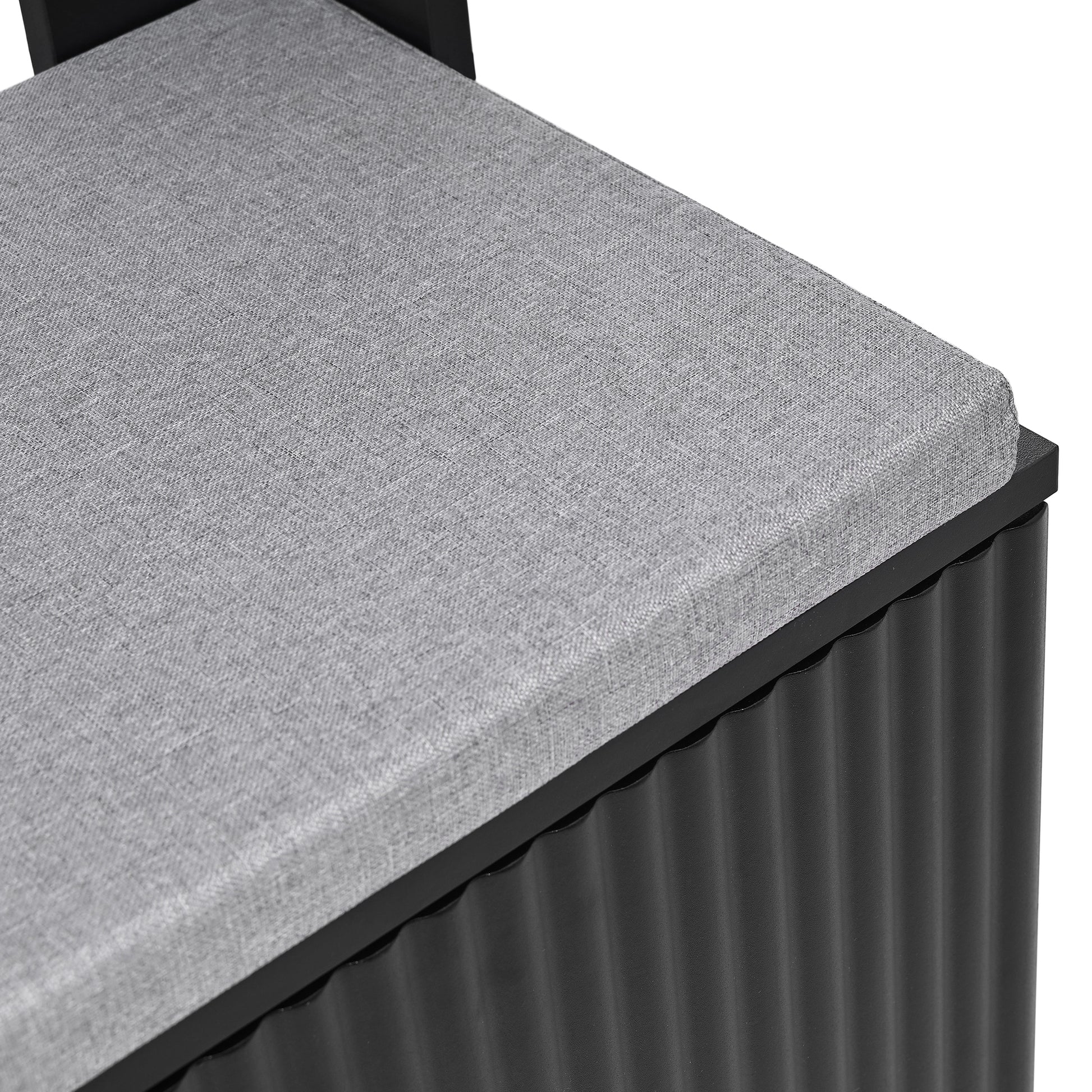 Grey upholstered storage ottoman with black corrugated base
