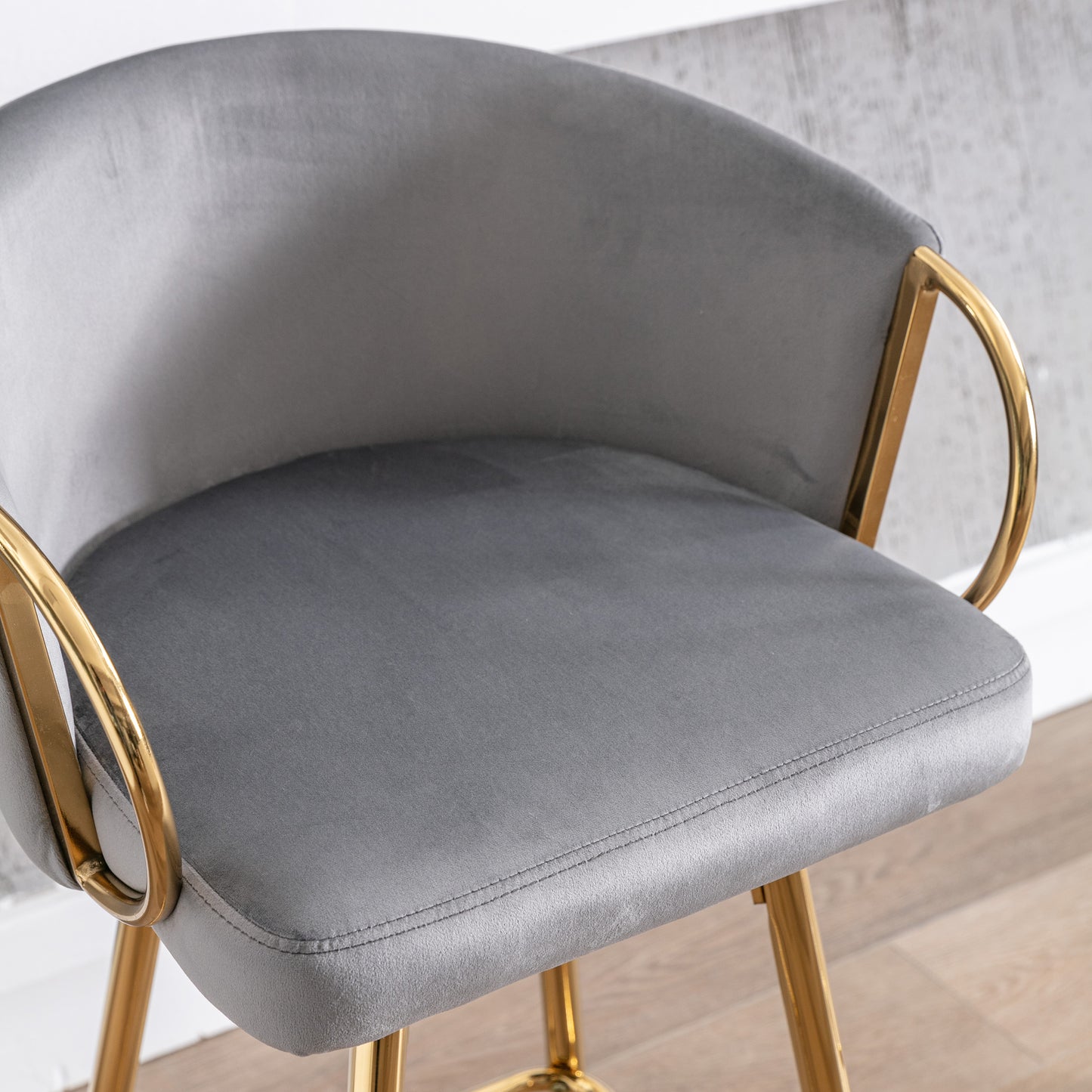 Grey velvet bar stool with gold metal legs and armrests