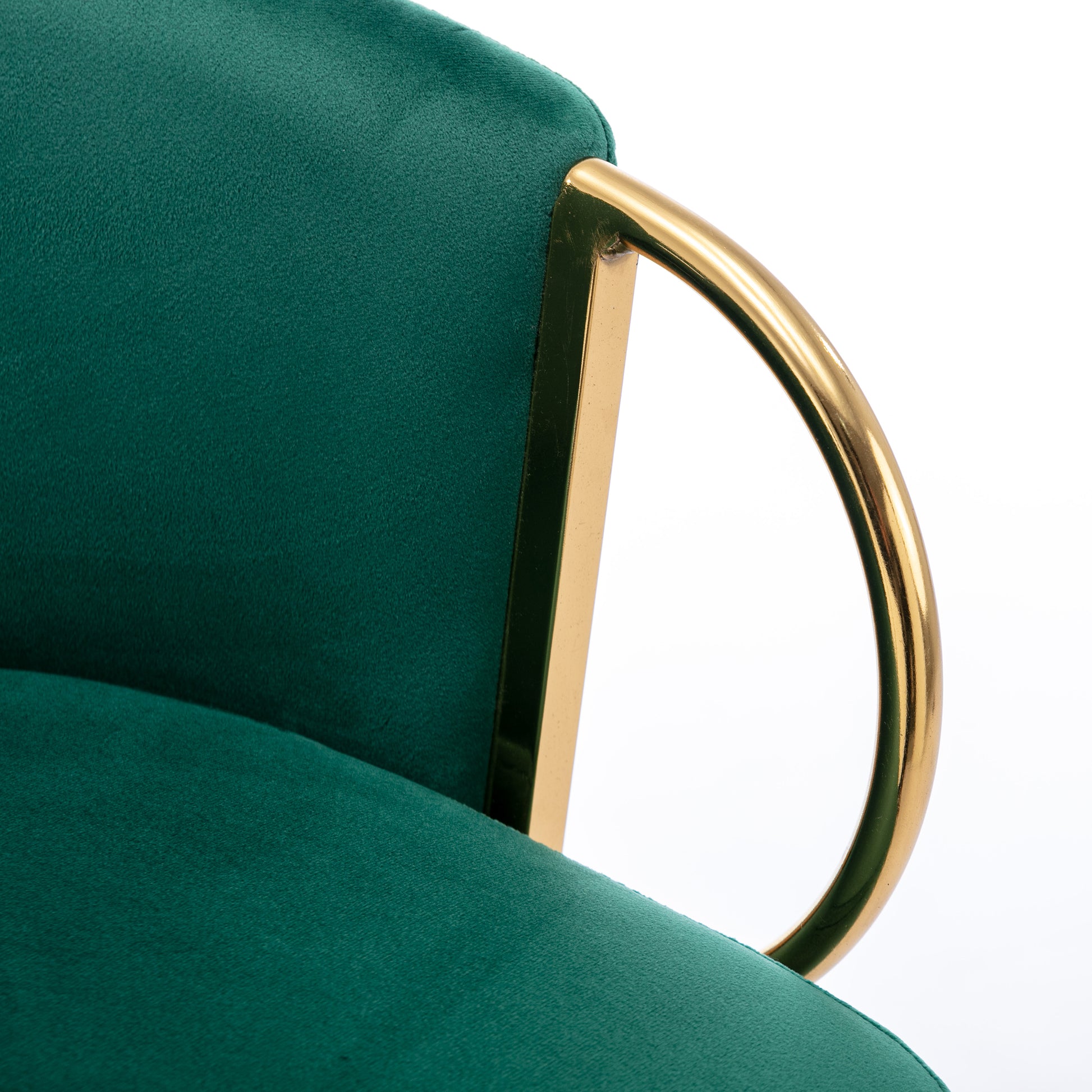 Emerald green velvet chair with polished gold armrest detail