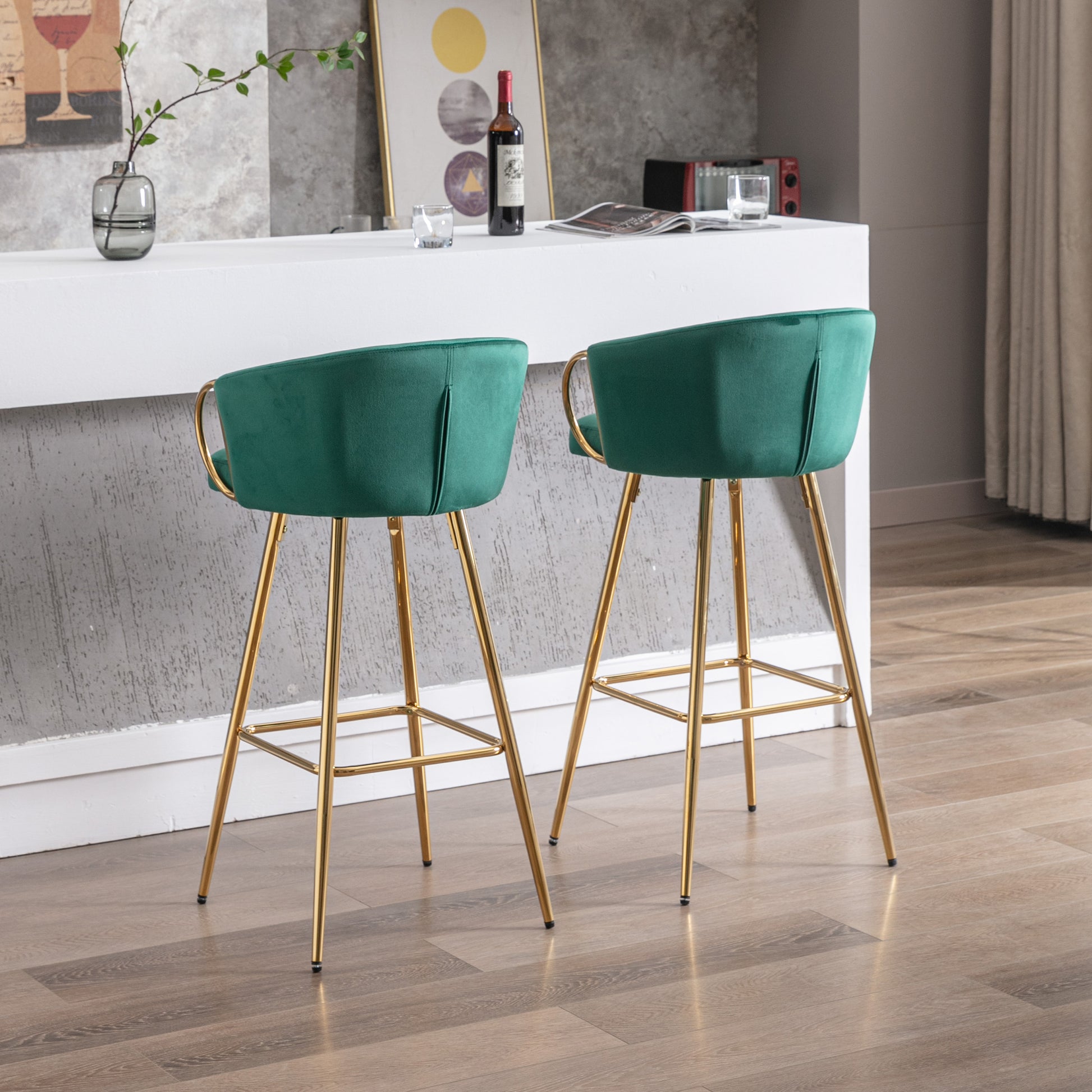Two emerald green velvet bar stools with gold legs perfect for modern kitchens