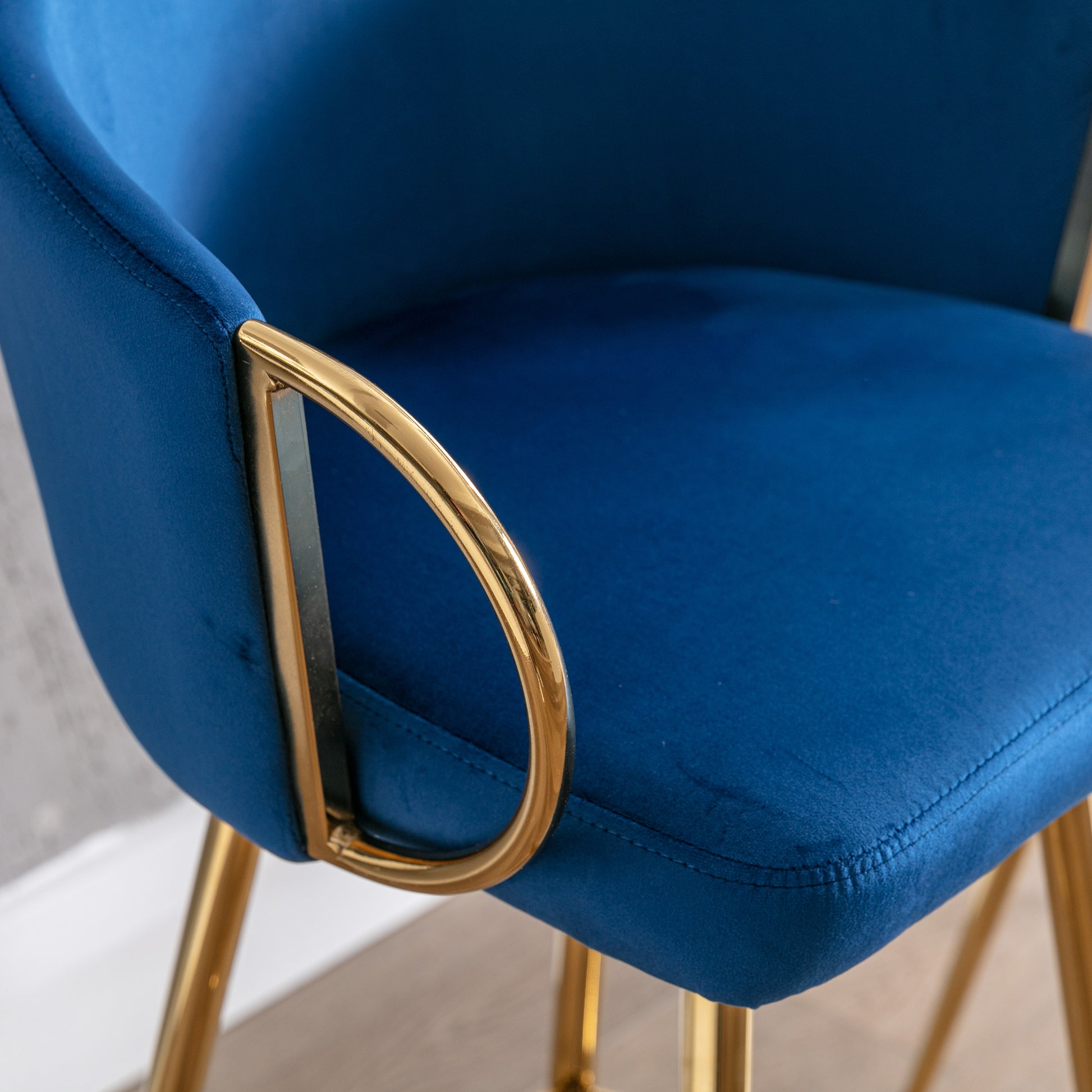 Deep blue velvet bar stool with gold metal accents and legs