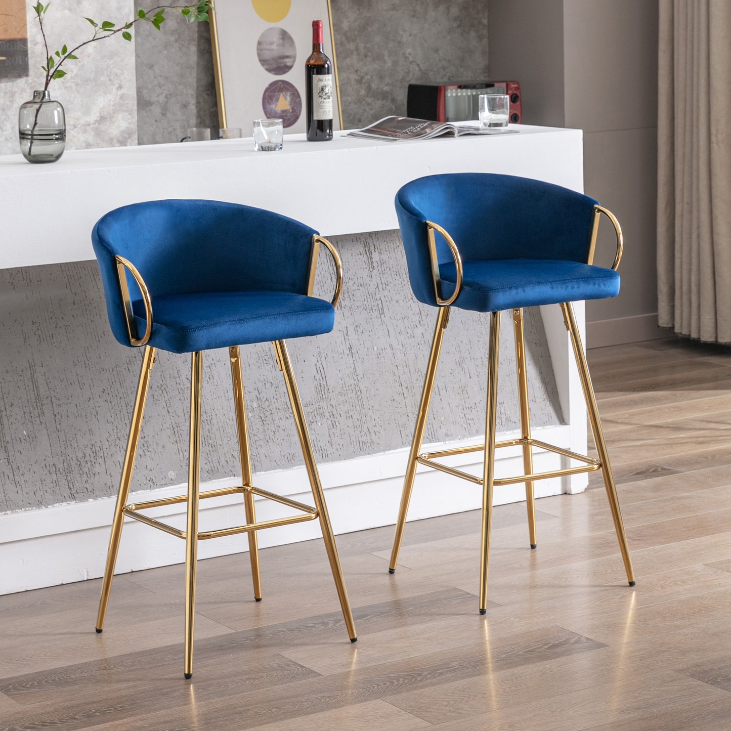 Two plush navy blue velvet bar stools with gold legs