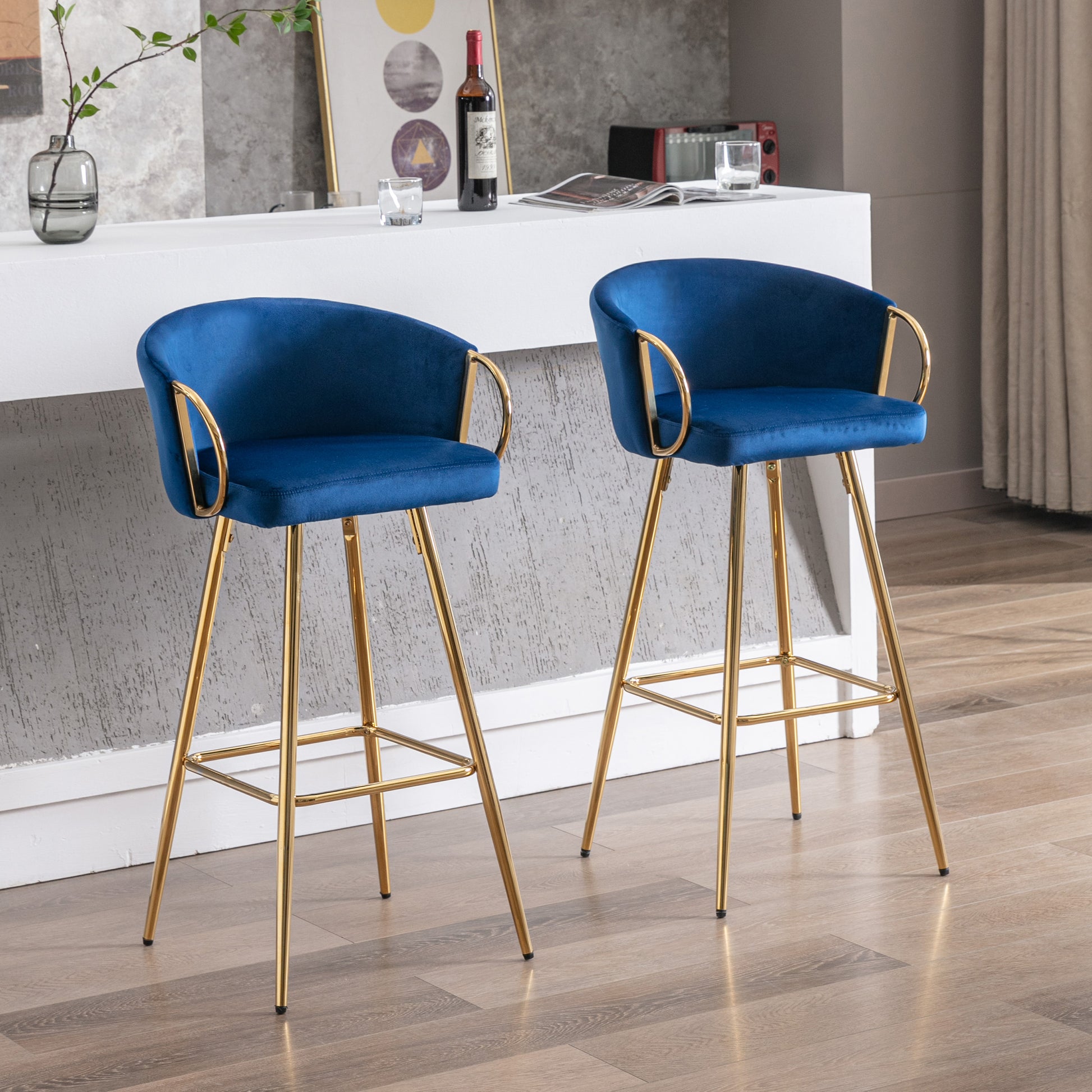 Two plush navy blue velvet bar stools with gold legs