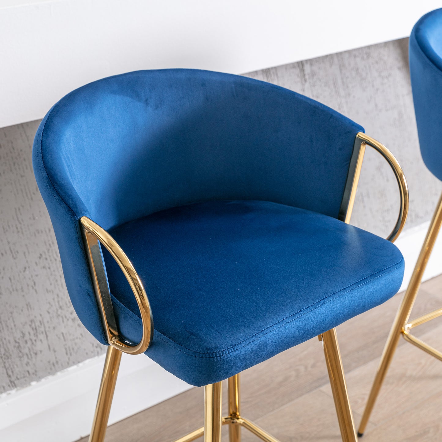 Navy blue velvet bar stool with gold legs and a curved back