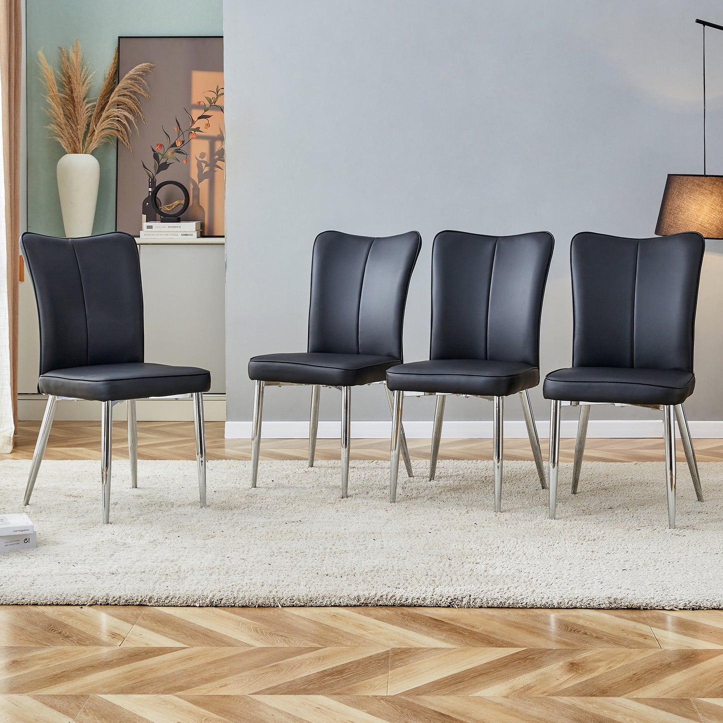 Four black faux leather dining chairs with chrome legs on a plush rug