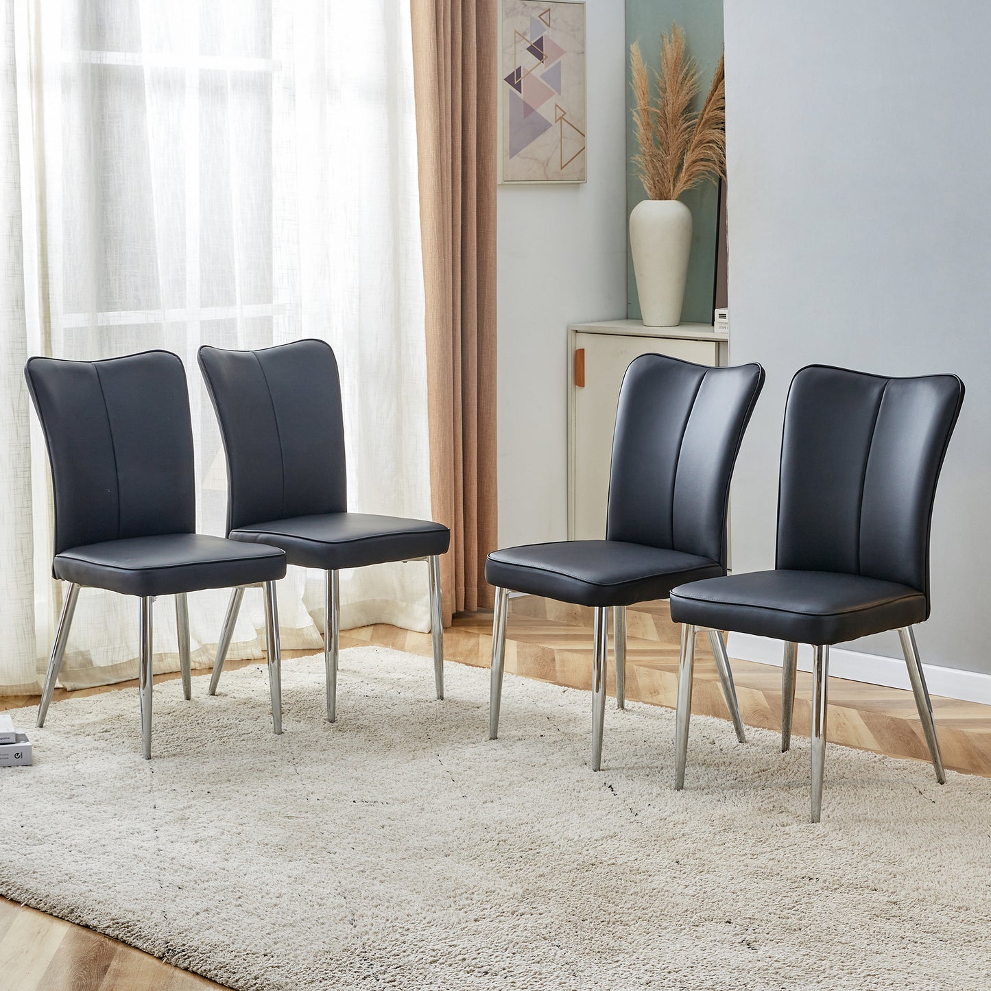 Four black faux leather dining chairs with chrome legs