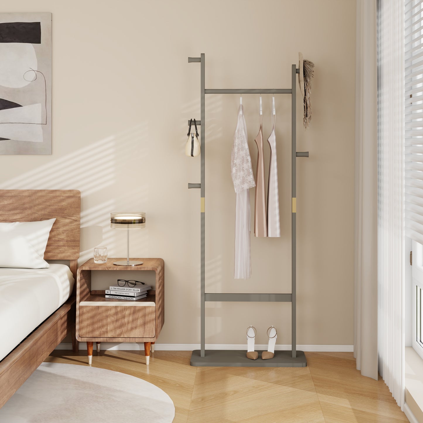 Modern grey metal garment rack with hanging dresses and beige handbag