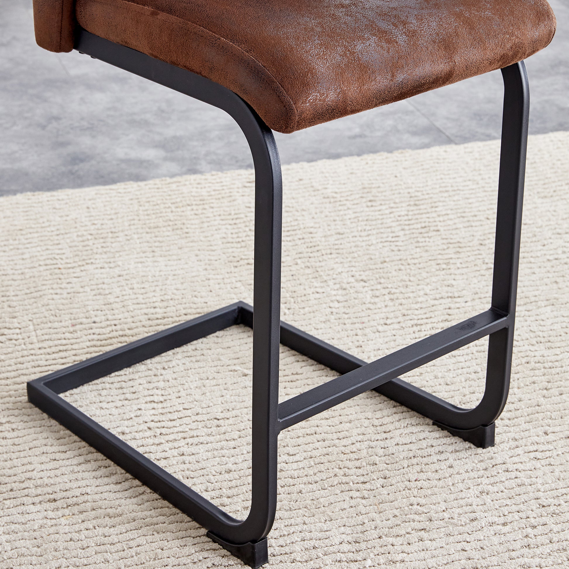 Brown faux leather counter stool with black metal legs on a cream rug
