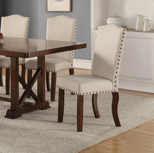 Upholstered dining chair in beige linen fabric with brass nailhead trim and dark wood legs